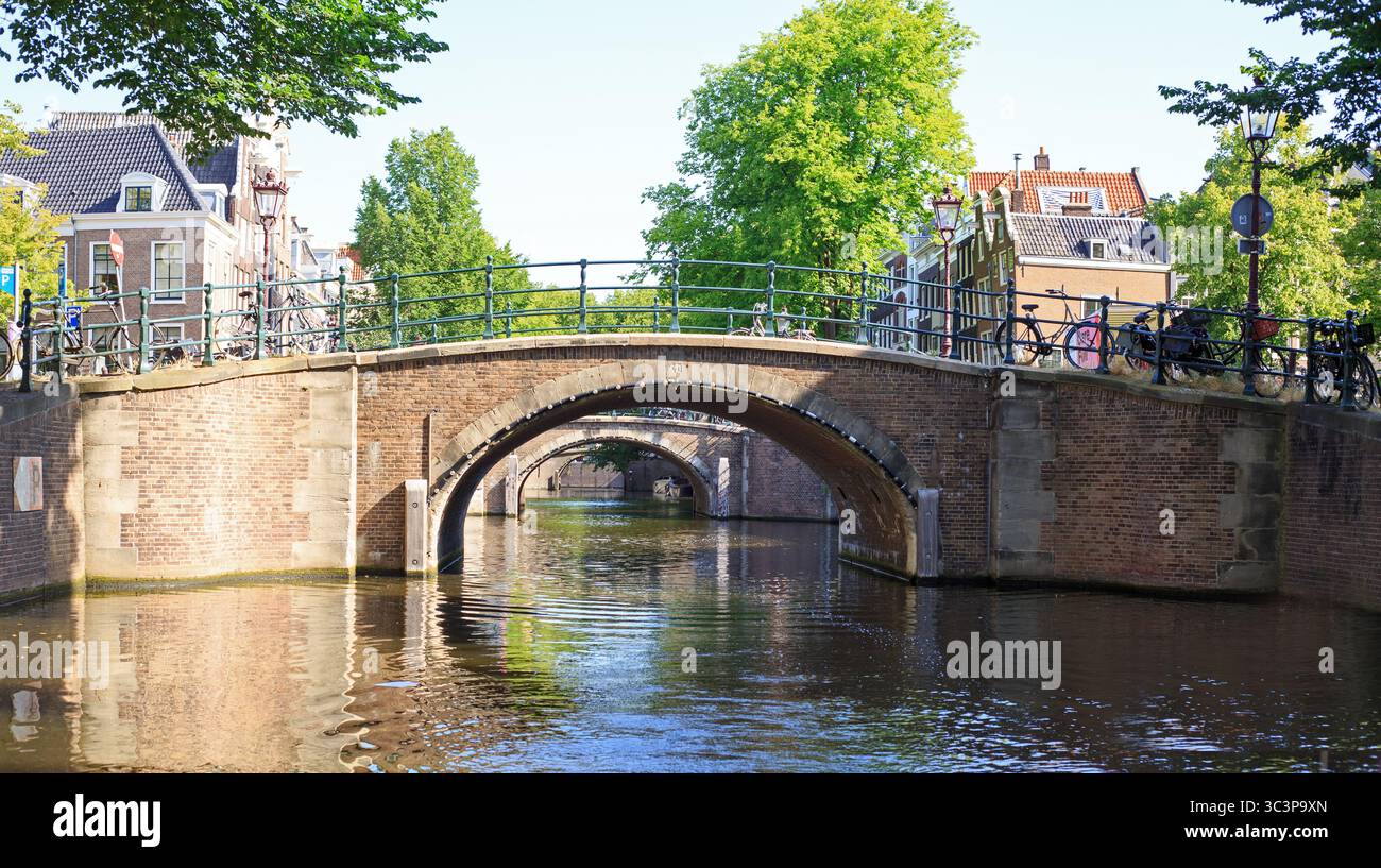 Crociera panoramica su uno dei canali di Amsterdam, con ponti ad arco Foto Stock
