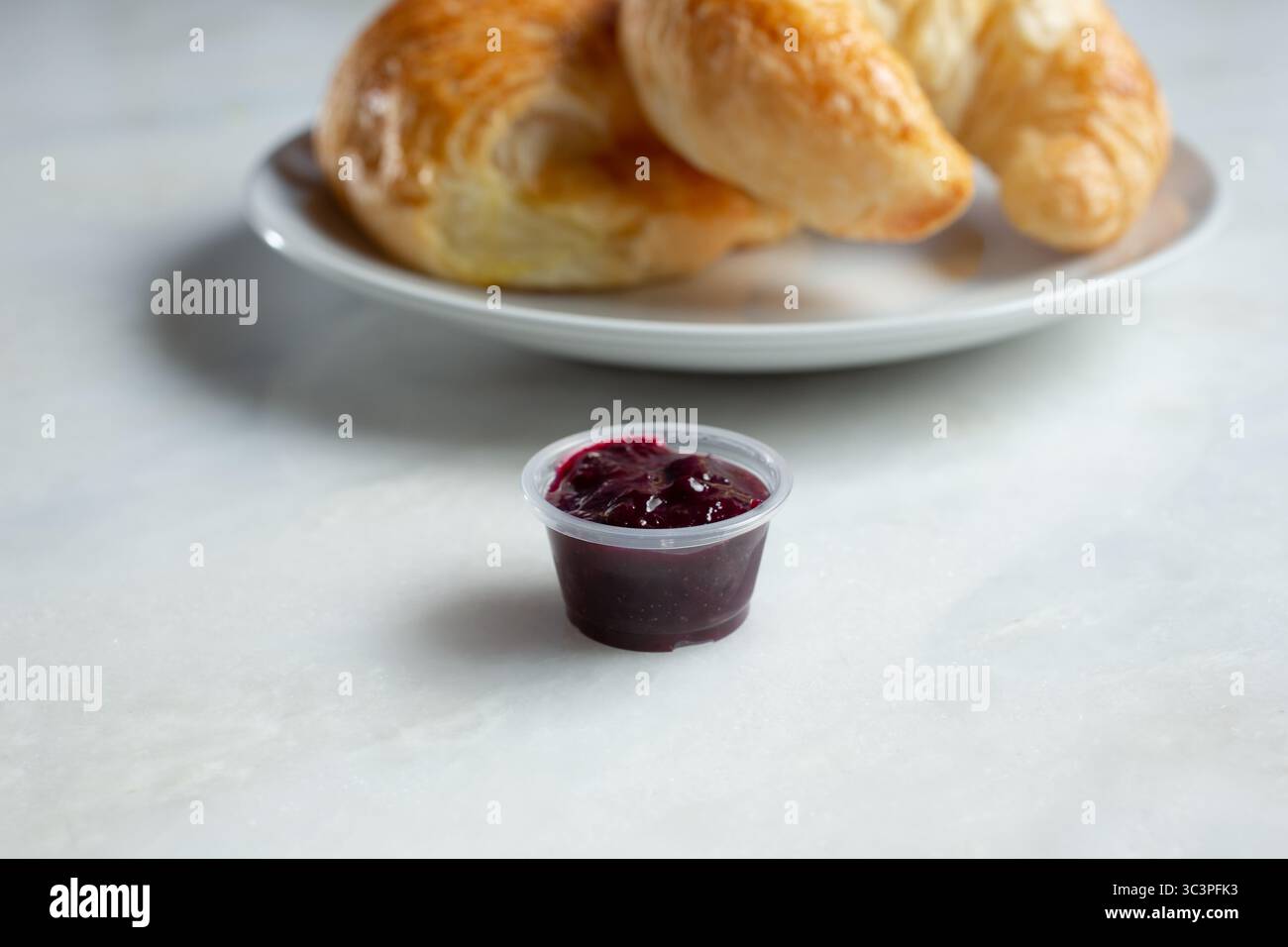 Vista di un bicchiere di plastica per condimenti riempito di gelatina. Foto Stock