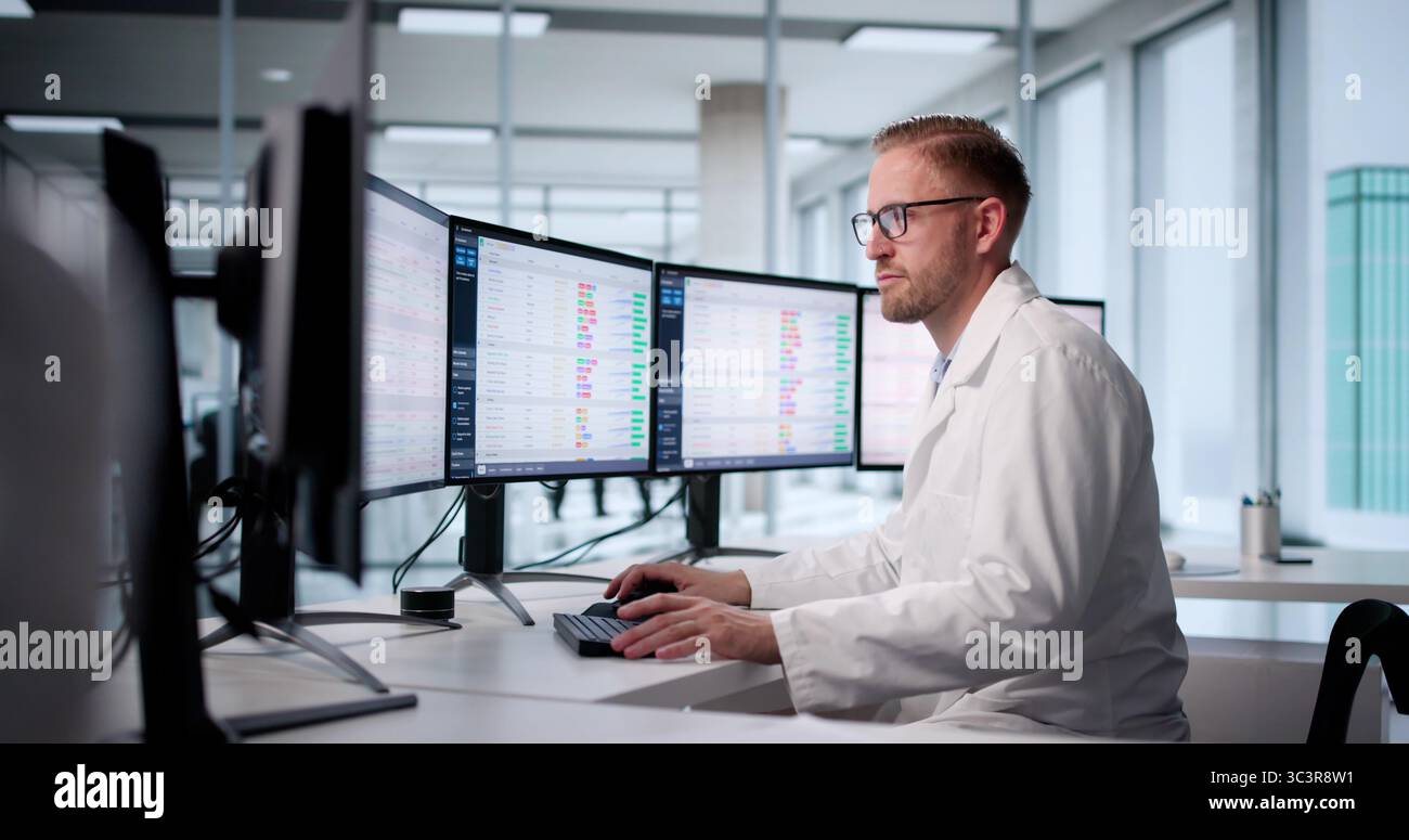Contabile medico che immette i codici di fatturazione sul computer desktop dell'ospedale Foto Stock