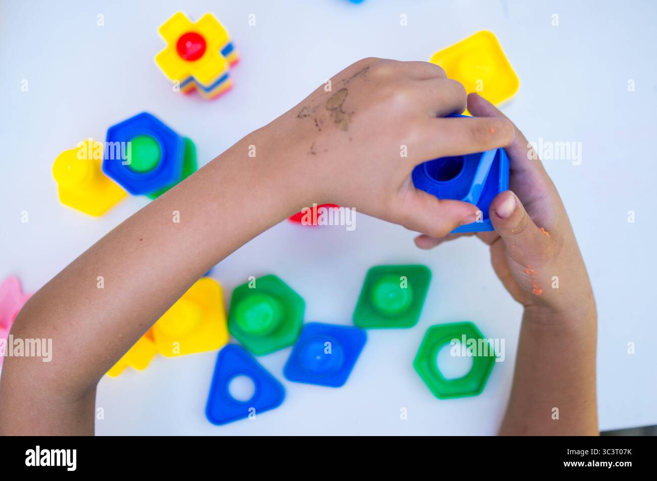 ragazzo che gioca con giochi di costruzione con pezzi multicolore Foto Stock