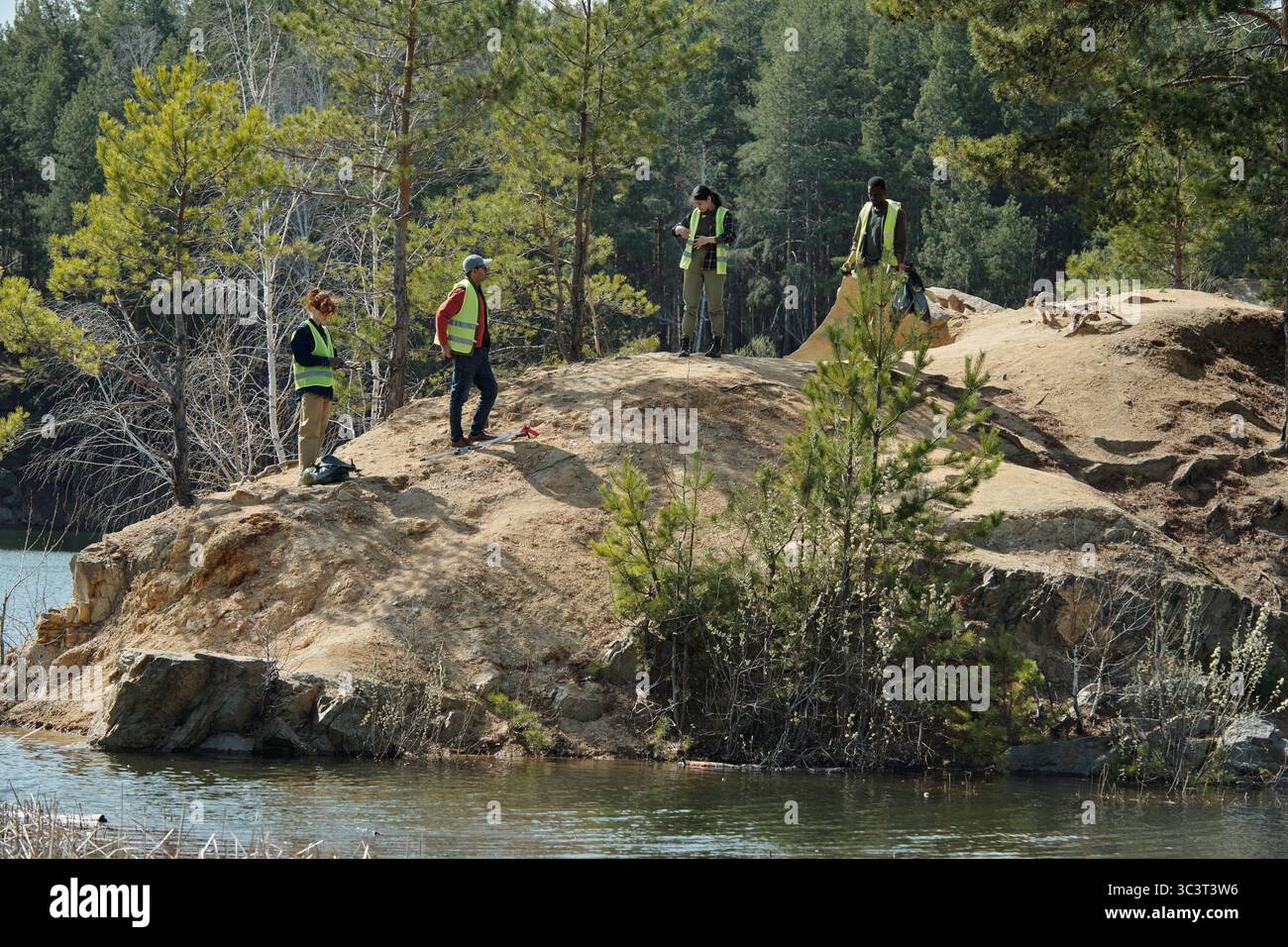 Gruppo di giovani adulti che puliscono la foresta Foto Stock