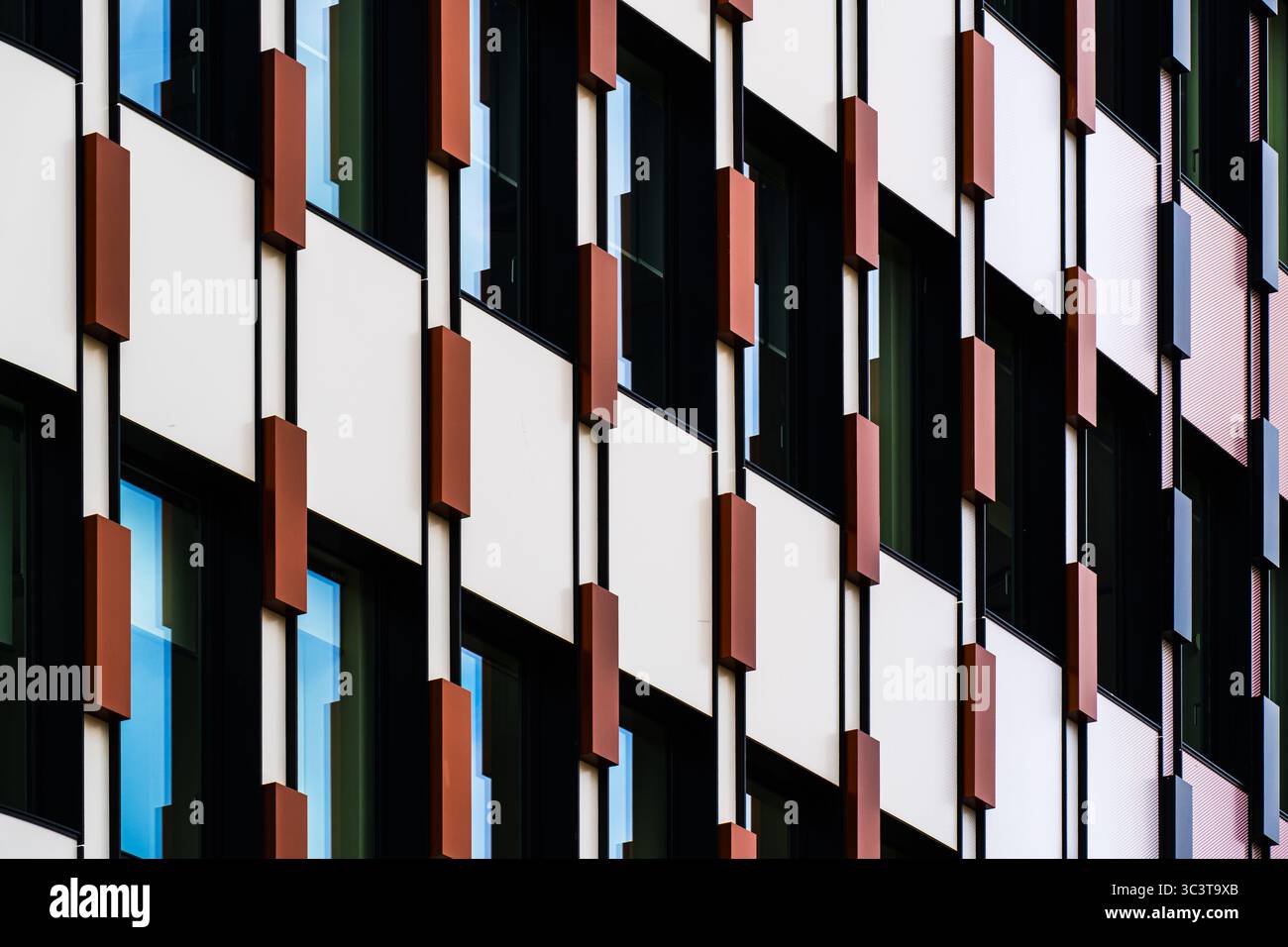 Facciata arancione e nera con elementi geometrici verticali Foto Stock