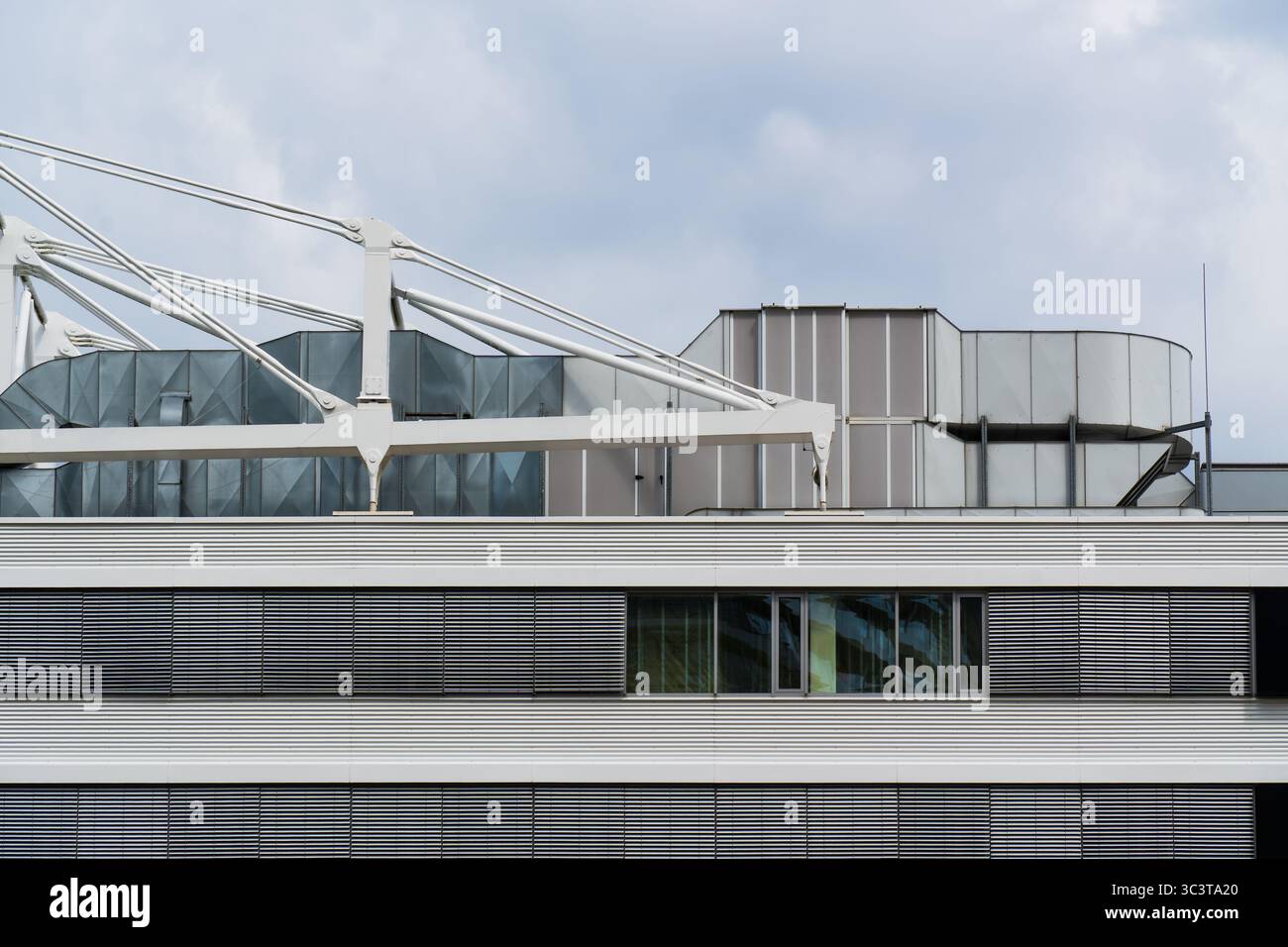Tetto di un edificio per uffici con installazioni tecniche e facciata orizzontale con sfinestratura Foto Stock