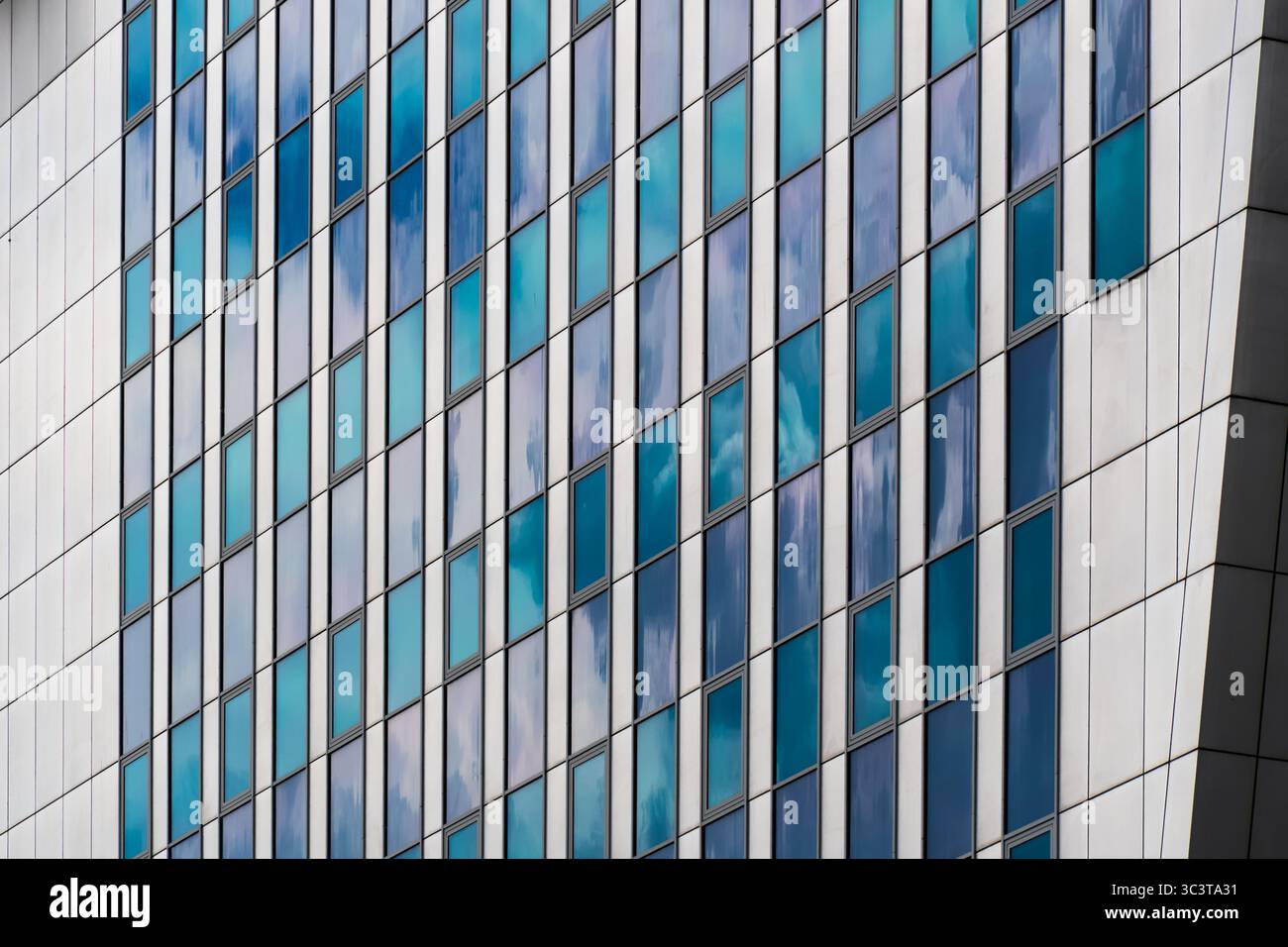 Facciata in vetro color crema e blu con finestre a griglia Foto Stock