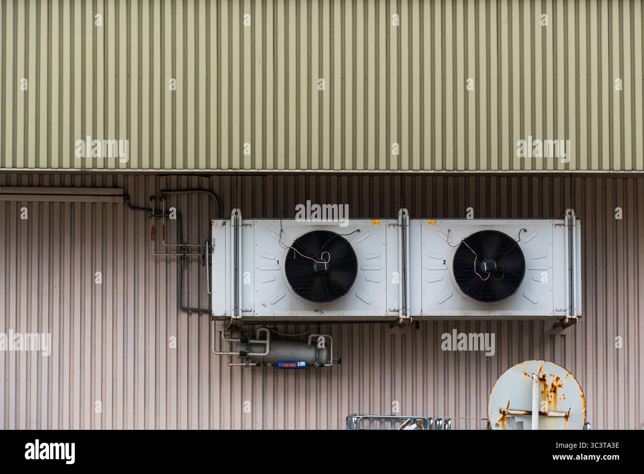 Unità di climatizzazione industriale esterna con ventole assiali doppie e sistema di tubazioni esposte Foto Stock