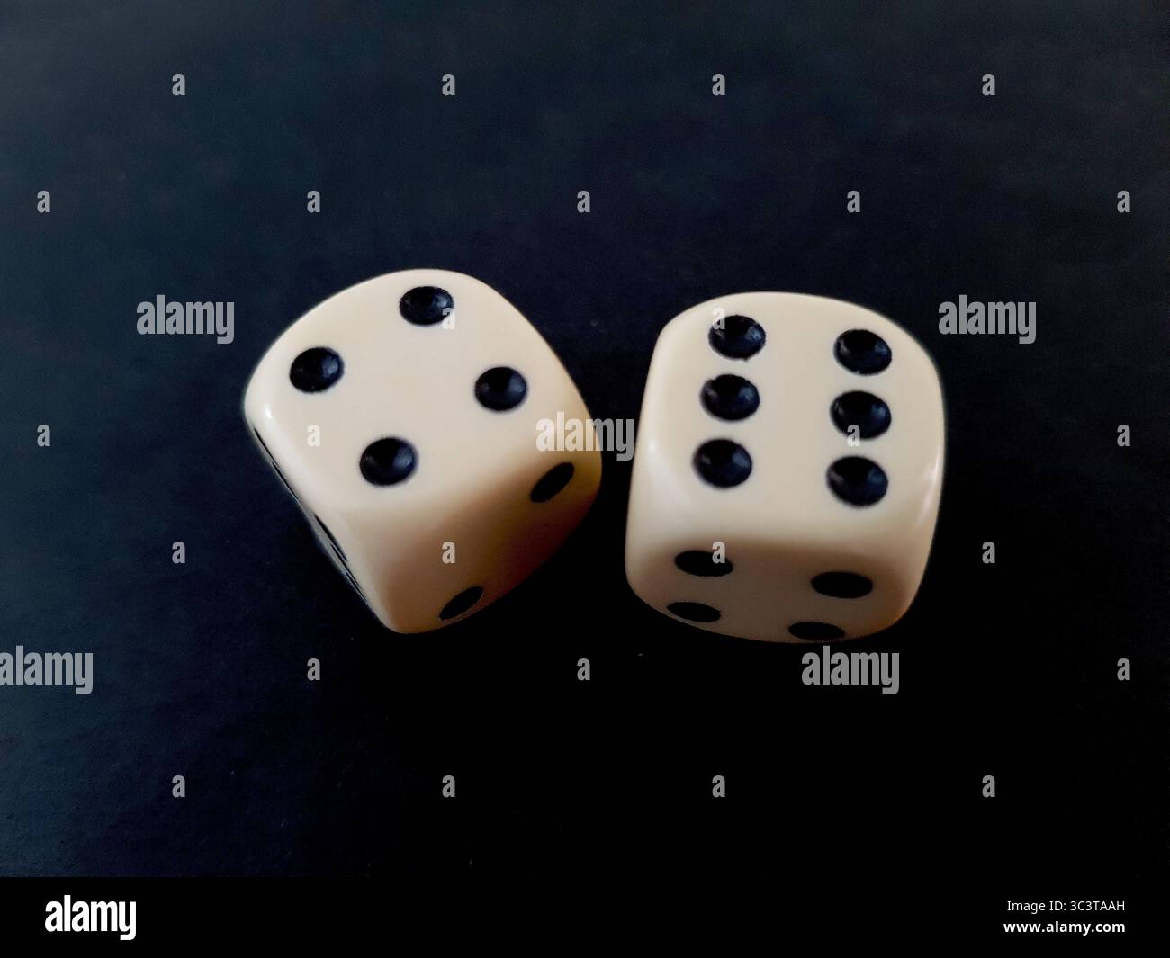 Un paio di dadi vintage isolati su sfondo nero. Foto Stock