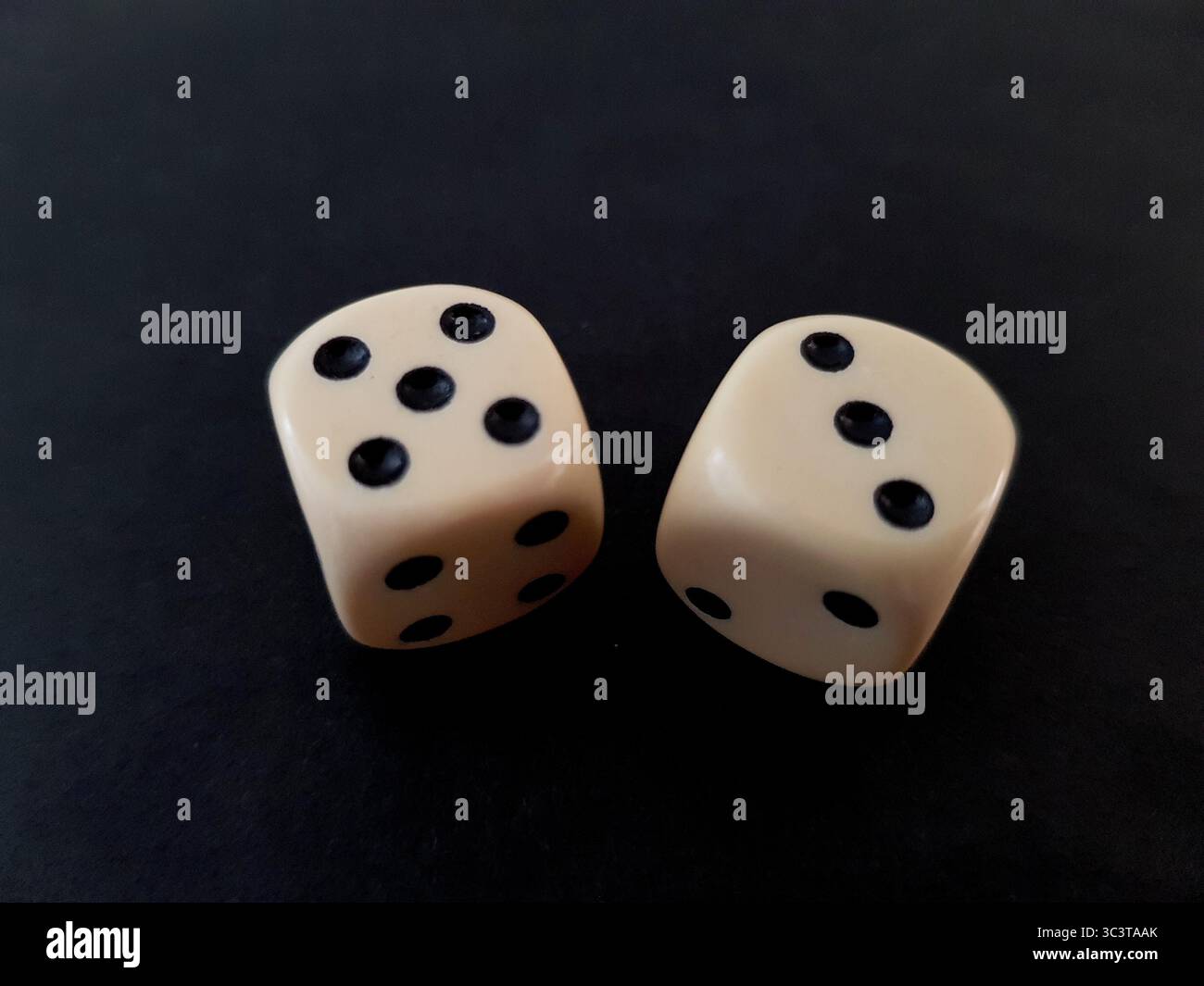Un paio di dadi vintage isolati su sfondo nero. Foto Stock