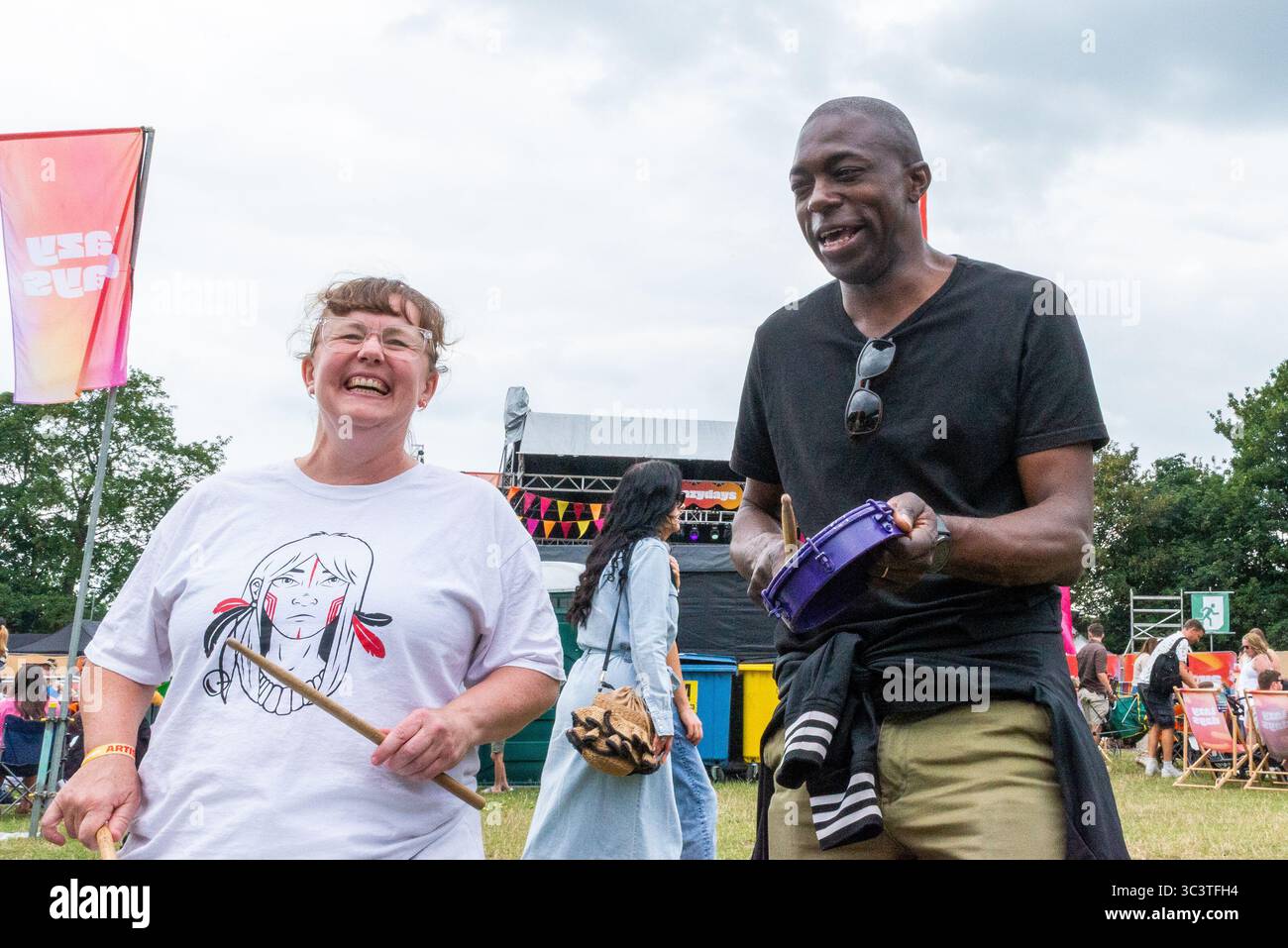 Priory Park, Southend on Sea, Essex, Regno Unito. 27 luglio 2025. Il deputato laburista per Southend East e Rochford si è offerto volontario per unirsi ai batteristi BrazilArte durante la visita al festival musicale Lazydays a Priory Park, Southend. La troupe di tamburi vagava per l'arena chiedendo casualmente ai membri del pubblico di unirsi al deputato che stava godendo del festival locale e lo ha convinto a partecipare. Autentica situazione non allestita Foto Stock