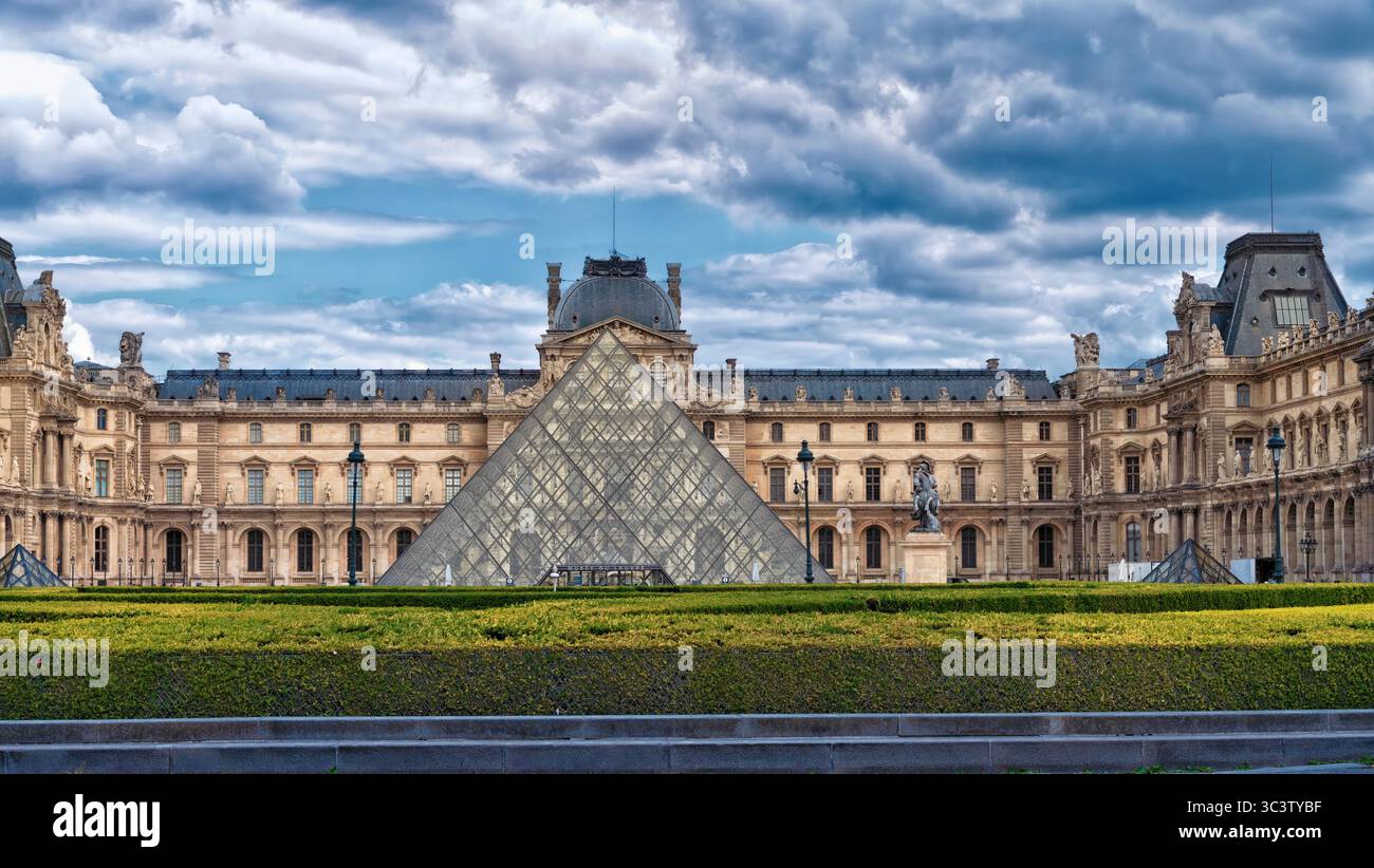 Parigi, Francia - 6 maggio 2025: Il Museo del Louvre di Parigi e la Cour Napoléon, il cortile principale, dominato dall'iconica piramide di vetro des Foto Stock