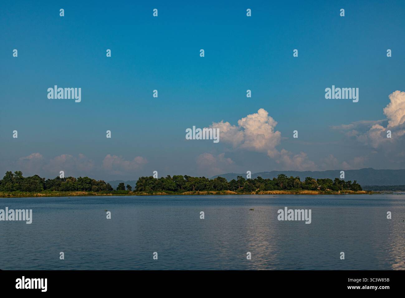 Nuvole in cima alla collina che incontrano la tranquilla superficie del lago Kaptai Foto Stock