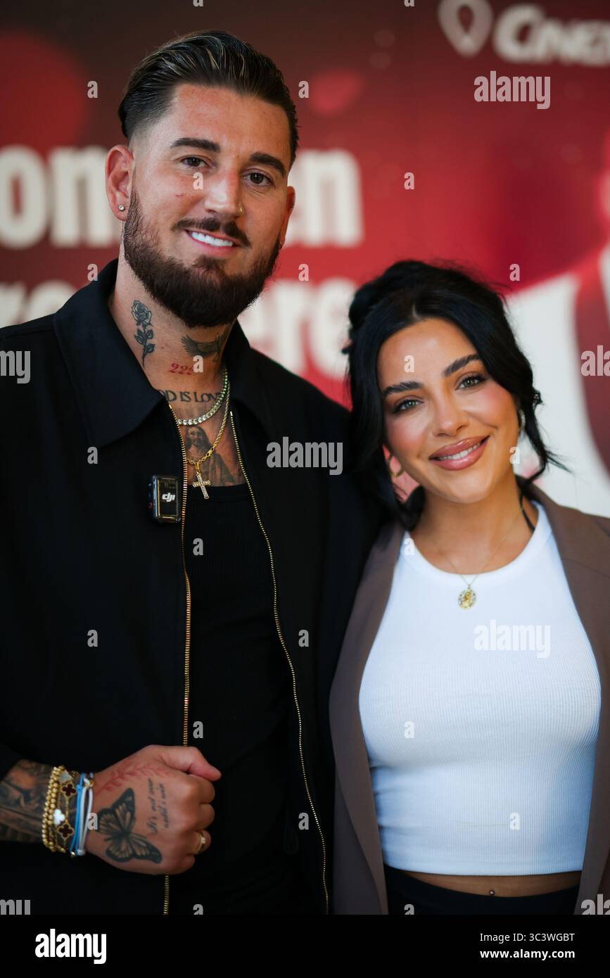 Essen, Germania. 27 luglio 2025. Le celebrità della reality TV Mike Heiter (l) e sua moglie Leyla Heiter, ex Leyla Lahouar, si trovano di fronte a un muro promozionale per il documentario sul loro matrimonio durante un servizio fotografico. Crediti: Christoph Reichwein/dpa/Alamy Live News Foto Stock