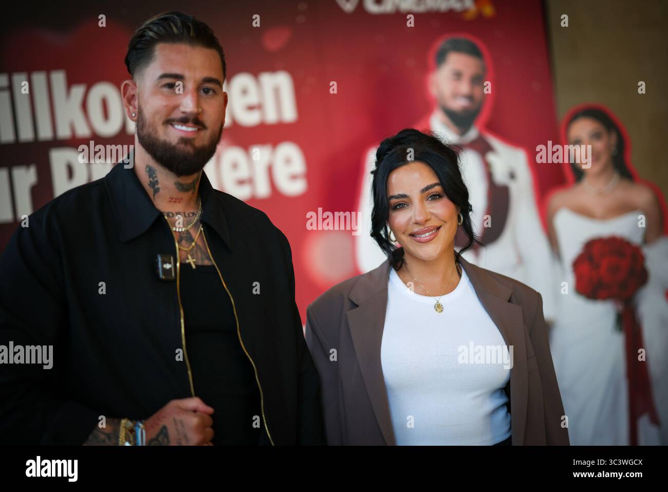 Essen, Germania. 27 luglio 2025. Le celebrità della reality TV Mike Heiter (l) e sua moglie Leyla Heiter, ex Leyla Lahouar, si trovano di fronte a un muro promozionale per il documentario sul loro matrimonio durante un servizio fotografico. Crediti: Christoph Reichwein/dpa/Alamy Live News Foto Stock