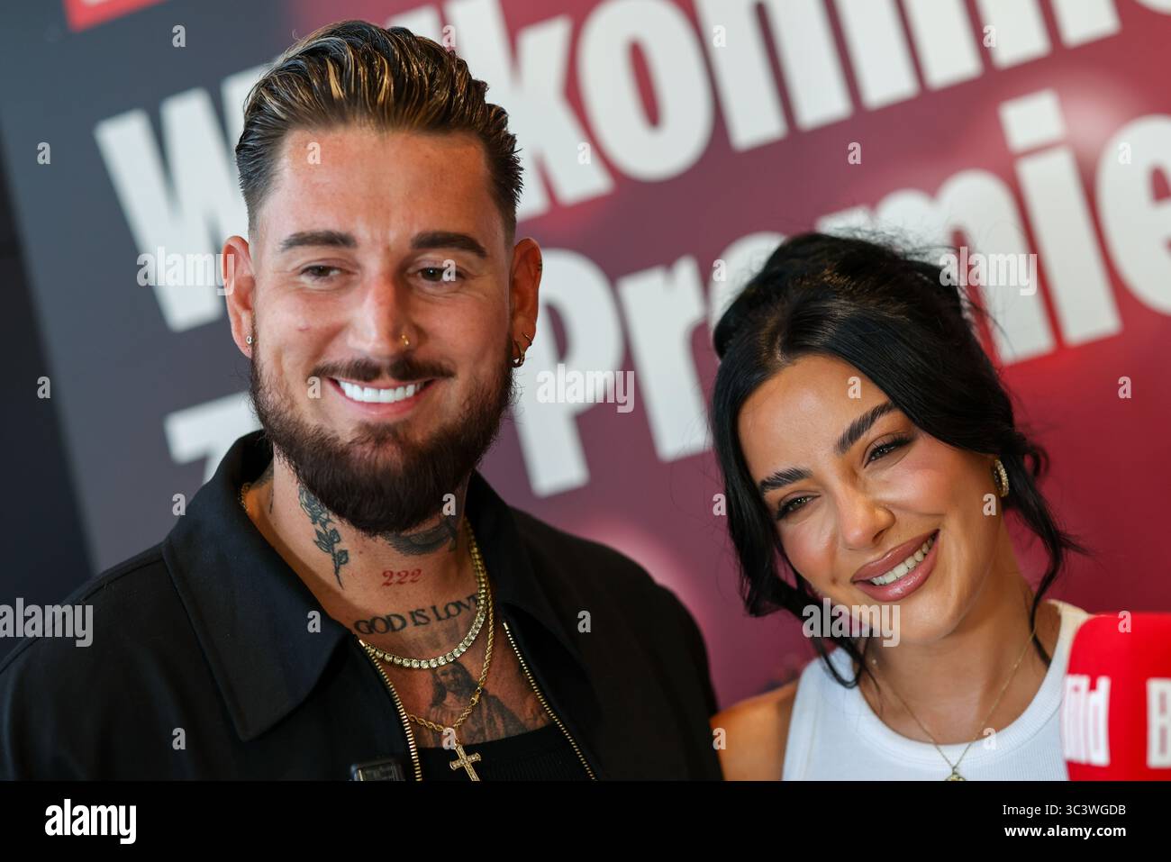 Essen, Germania. 27 luglio 2025. Le celebrità della reality TV Mike Heiter (l) e sua moglie Leyla Heiter, ex Leyla Lahouar, si trovano di fronte a un muro promozionale per il documentario sul loro matrimonio durante un servizio fotografico. Crediti: Christoph Reichwein/dpa/Alamy Live News Foto Stock