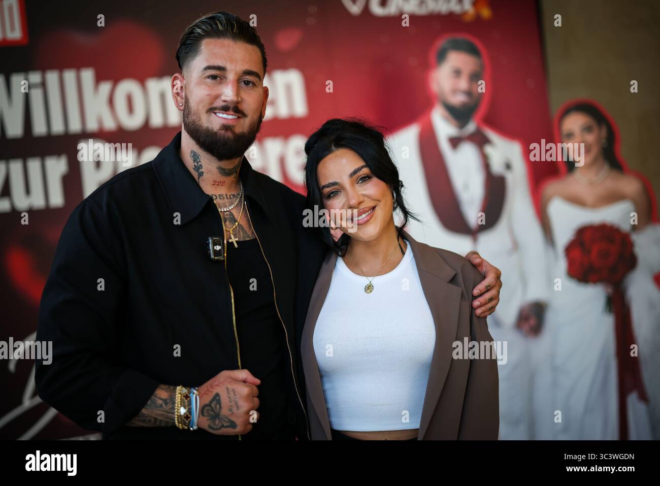 Essen, Germania. 27 luglio 2025. Le celebrità della reality TV Mike Heiter (l) e sua moglie Leyla Heiter, ex Leyla Lahouar, si trovano di fronte a un muro promozionale per il documentario sul loro matrimonio durante un servizio fotografico. Crediti: Christoph Reichwein/dpa/Alamy Live News Foto Stock