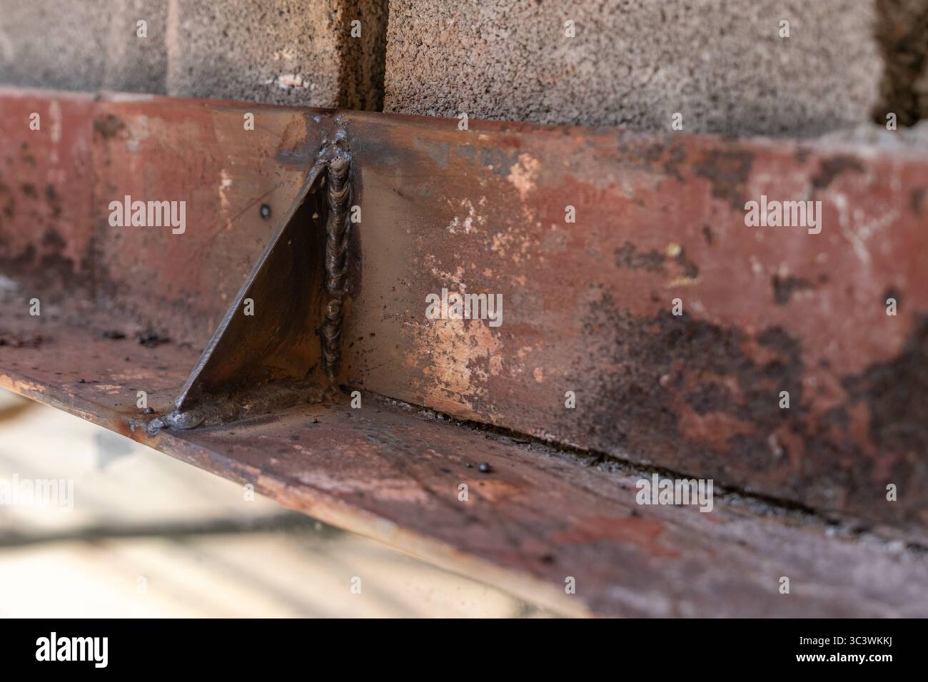 Primo piano di un architrave strutturale in acciaio esistente da rinforzare, riparato prima della reinstallazione dei mattoni. Foto Stock