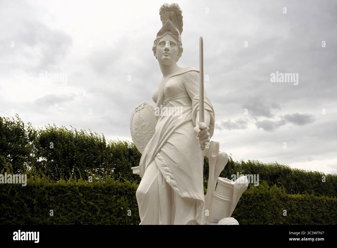 Ritratto frontale, ad angolo verso l'alto, di una statua in arenaria dell'antica dea greca Europa (Europa) con spada e scudo nei Giardini di Herrenhausen, Hannover Foto Stock