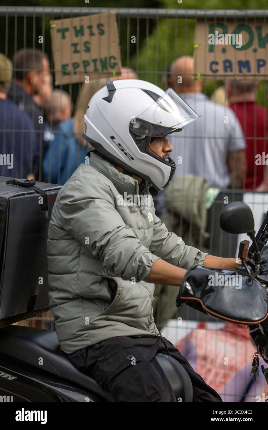 Epping, Regno Unito. 27 luglio 2025 i manifestanti anti anti-immigrazione si sono riuniti fuori dal Bell Hotel a Epping domenica 27 luglio, incontrati da una contro-manifestazione organizzata da Stand Up to Racism. Entrambi i gruppi si trovavano di fronte ai lati opposti di un cordone forzato dalla polizia, con una presenza particolarmente pesante della polizia che manteneva la separazione per tutto lo stallo. Credito: Abdullah Bailey/Alamy Live News Foto Stock