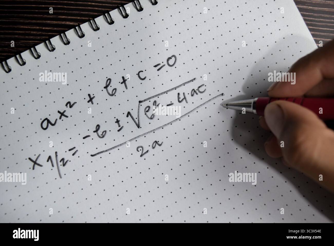 Concetto di equazione quadratica generale scrivere su libro isolato su tavolo di legno. Foto Stock