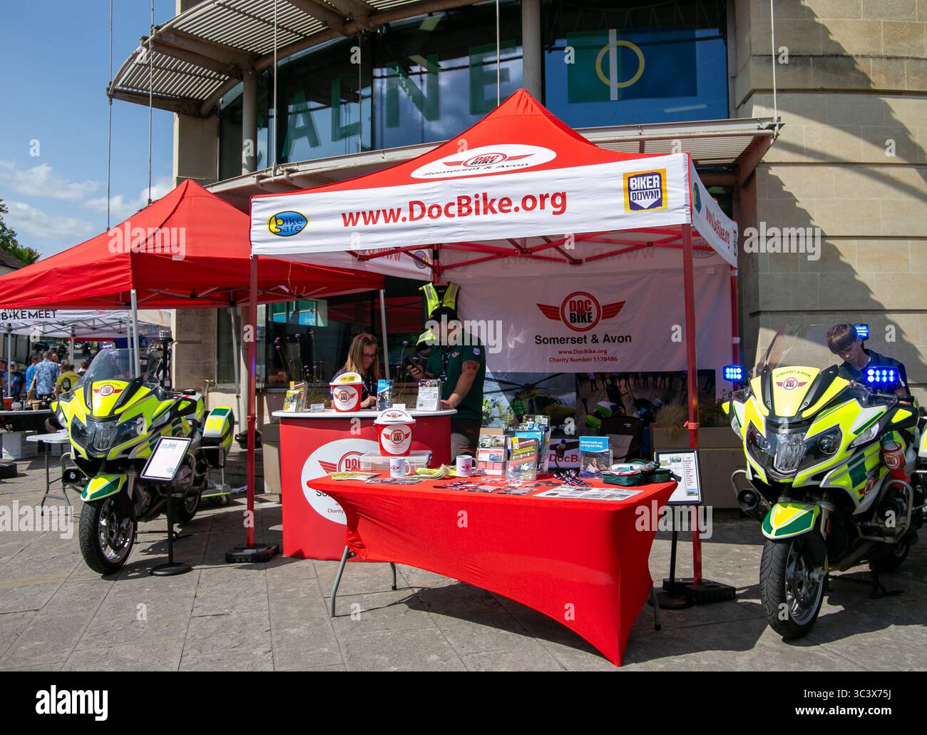 Un allestimento di beneficenza DocBike con due motociclette e una tenda promozionale rossa, che promuove la consapevolezza della sicurezza stradale e motociclistica al Calne bike Meet 2025 Foto Stock