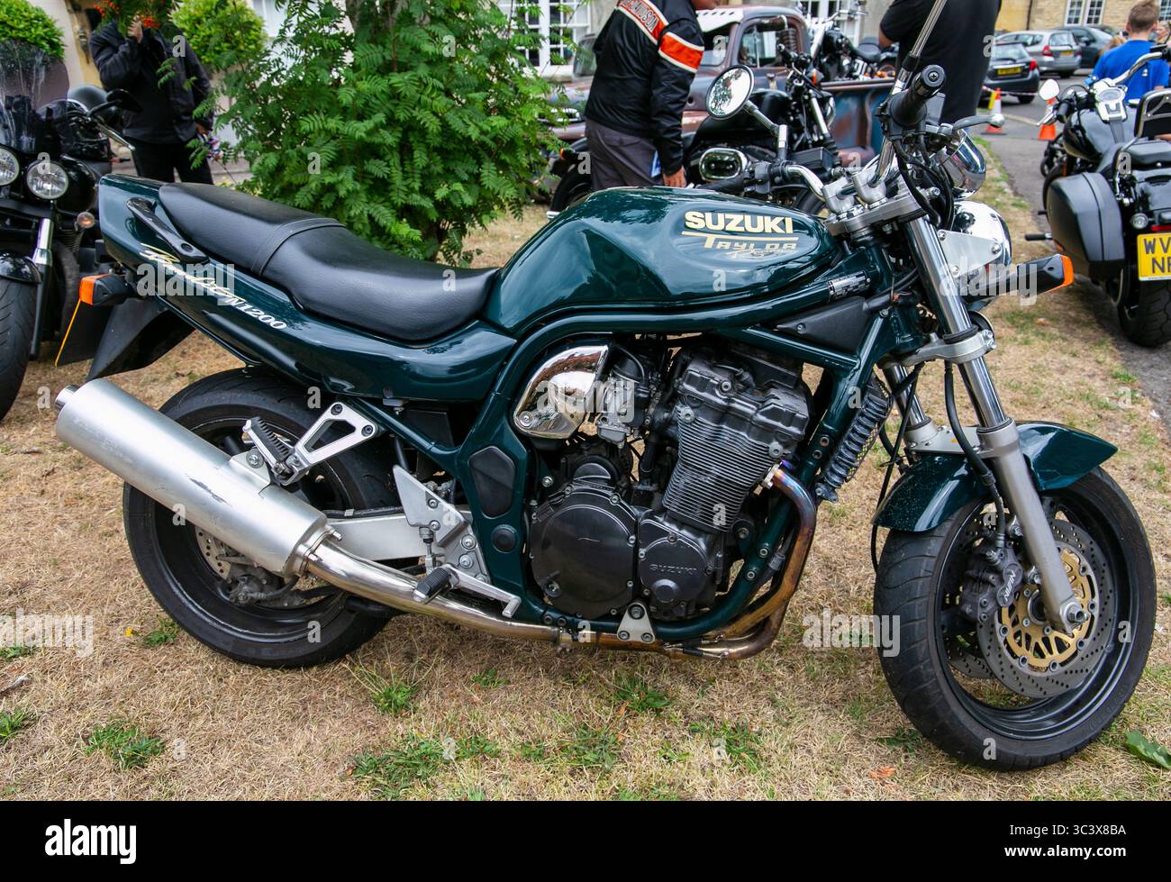 Una classica motocicletta verde Suzuki Bandit N1200 con Taylor racing esposta in un parco circondato da altre motociclette al Calne bike Meet Foto Stock