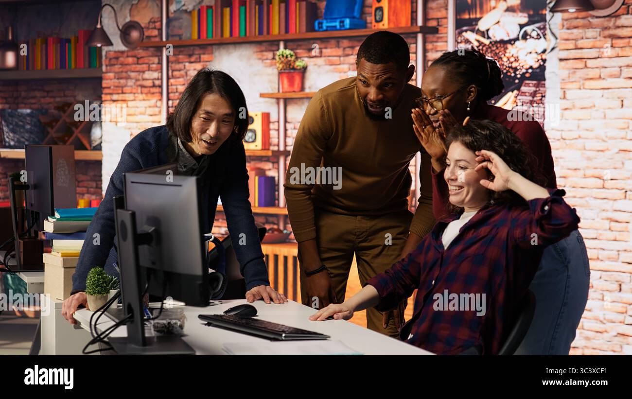 Felice team di startup multietnico che celebra l'alta valutazione in borsa, raccogliendo fondi. Imprenditori tecnologici felici che si assicurino investimenti da angelo, diventando un'azienda di unicorno, telecamera B. Foto Stock