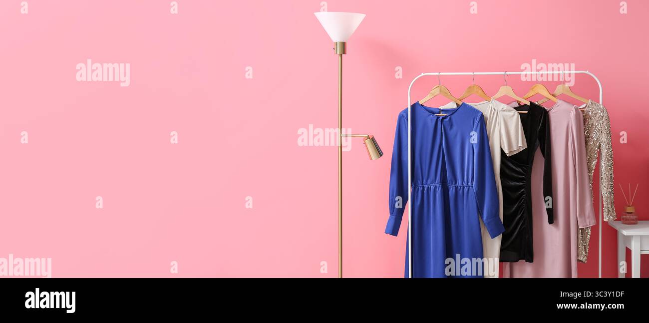 Piantana e appendiabiti eleganti vicino alla parete rosa. Banner per il design Foto Stock