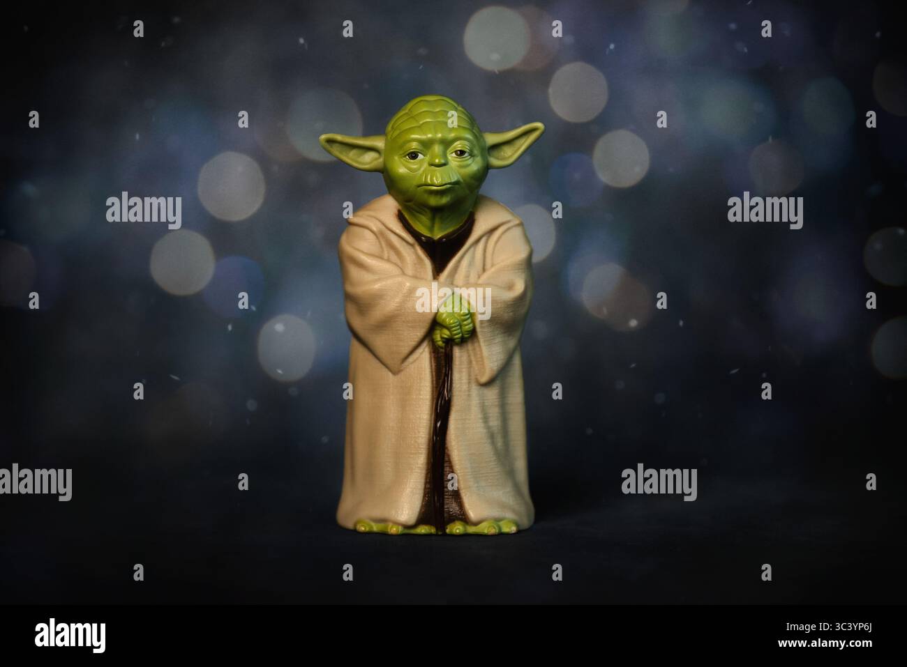 Primo piano del personaggio Yoda della saga cinematografica di Star Wars su uno sfondo astratto. Editoriale illustrativo Foto Stock