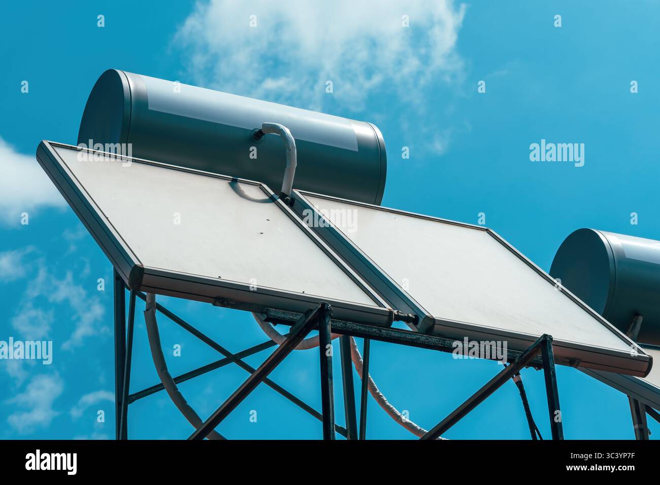Primo piano del sistema di riscaldamento dell'acqua solare sul tetto sotto un cielo azzurro. Concetto di energia pulita e tecnologia sostenibile.attenzione selettiva. Foto Stock