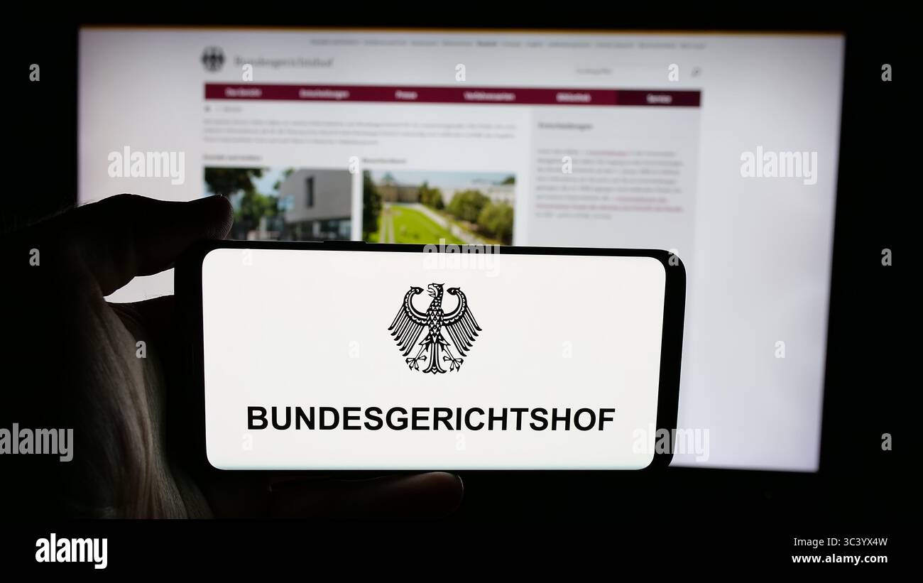 Stoccarda, Germania - 06-11-2025: Persona che tiene il cellulare con il logo del tribunale federale tedesco Bundesgerichtshof (BGH) sullo schermo davanti alla pagina web. Foto Stock