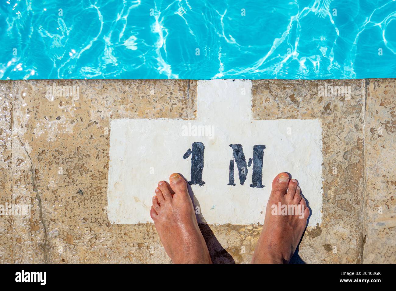 Piedi di uomo caucasico vicino al bordo di una piscina profonda 1 metro. Foto Stock