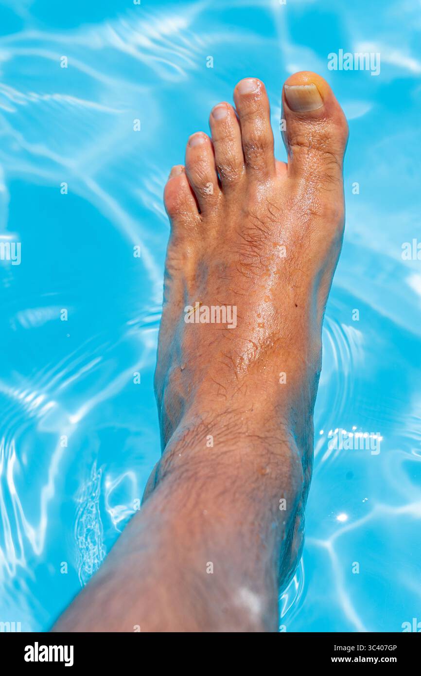 Bellissimi piedi con 30 centimetri di bianco uomo caucasico all'interno di acqua blu e piscina Foto Stock