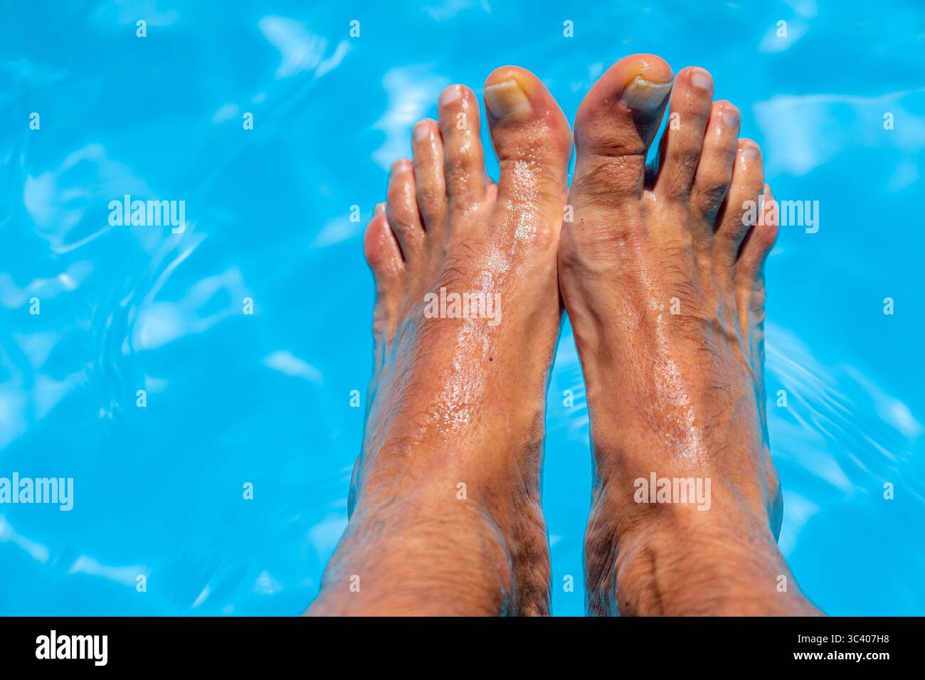 Bellissimi piedi con 30 centimetri di bianco uomo caucasico all'interno di acqua blu e piscina Foto Stock