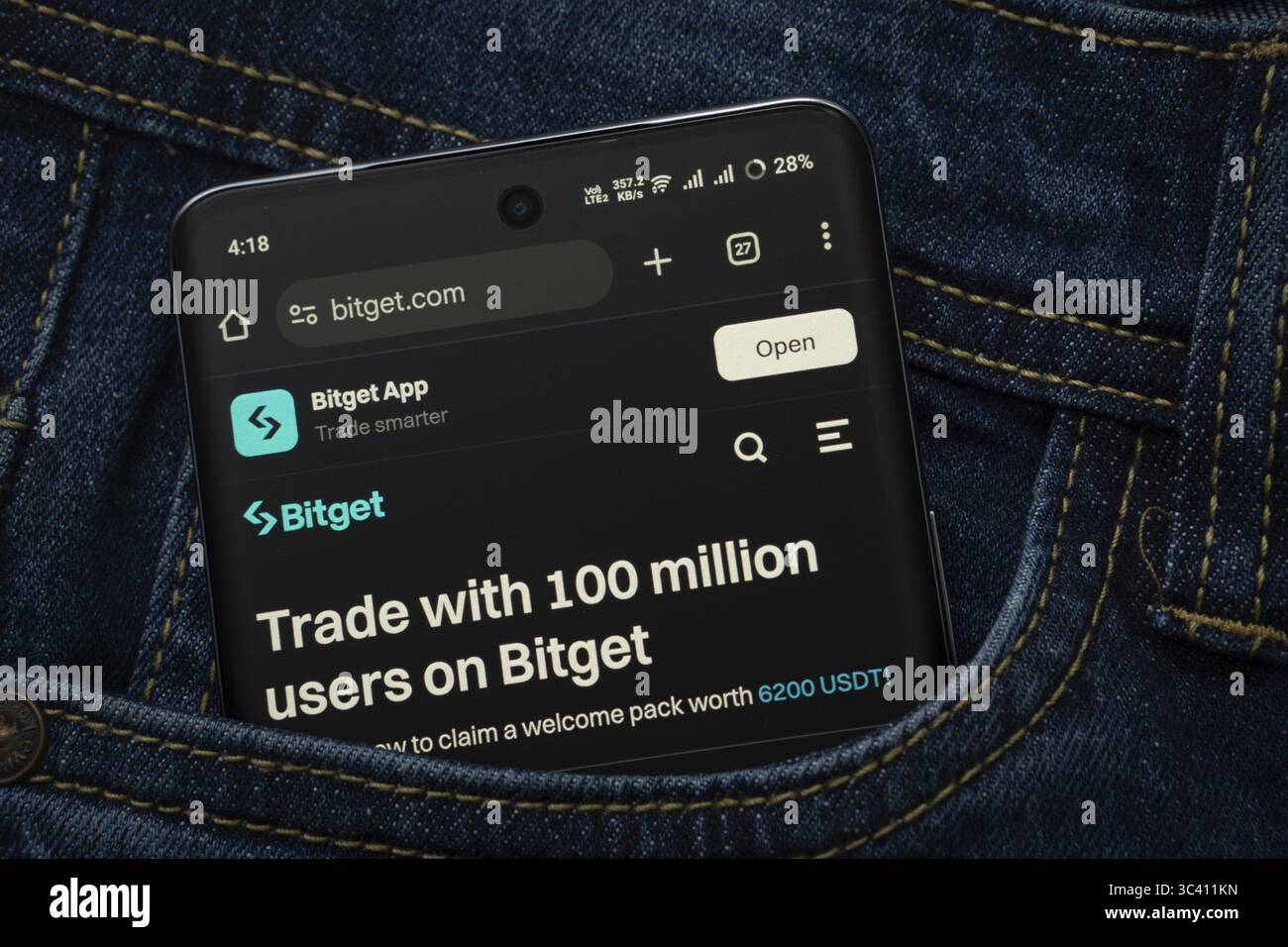 Dhaka, Bangladesh- 15 giugno 2025: Uno smartphone che visualizza l'interfaccia Web (--).com sbuca fuori da una tasca in denim Foto Stock
