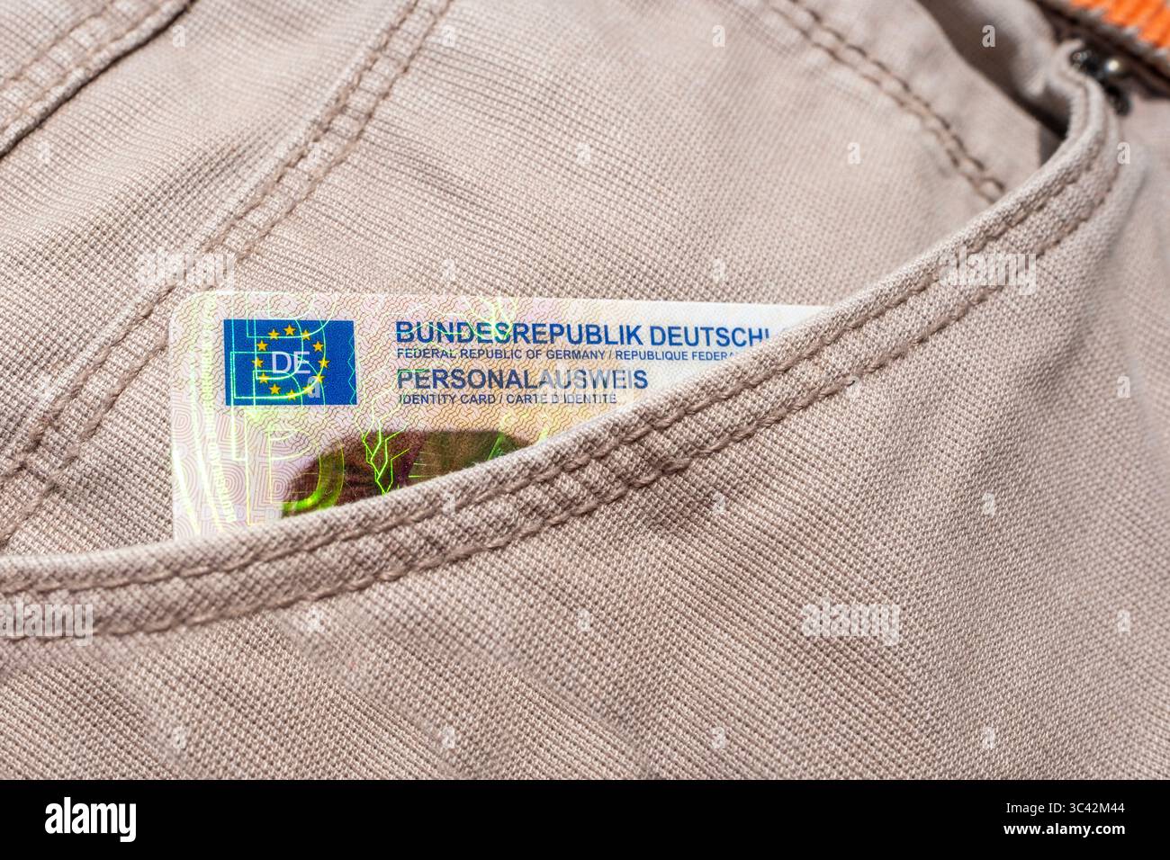 Carta d'identità tedesca con bandiera UE in tasca per i jeans, documento personale europeo moderno, integrazione europea e diritti legali, viaggio dei cittadini dell'UE, passaporto con Foto Stock