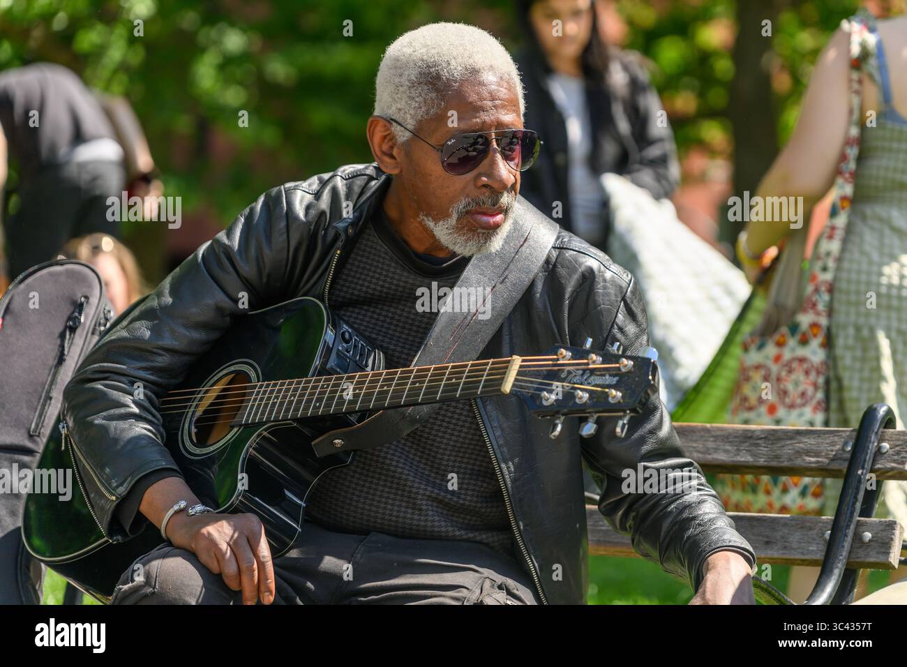Un aviatore Ray-Ban che indossa Musical Street Performer con chitarra Takamine a Washington Square Park, Greenwich Village, New York, USA. Foto Stock