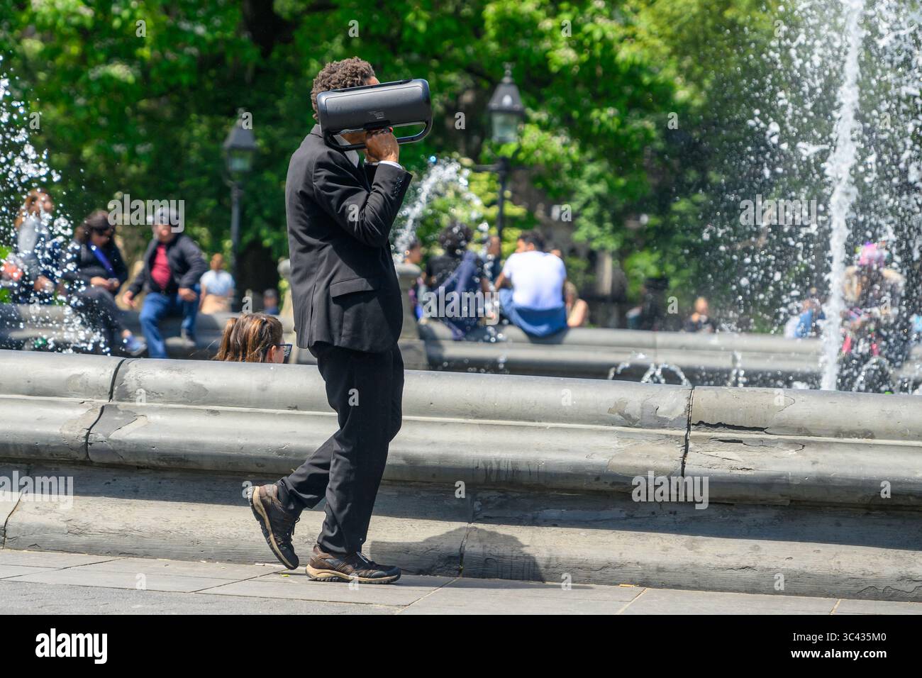 Un uomo adatto ascolta il suo Boombox mentre cammina attraverso Washington Square Park, New York. Foto Stock Un uomo adatto ascolta il suo Boombox mentre cammina attraverso Washington Square Park, New York. Foto Stock