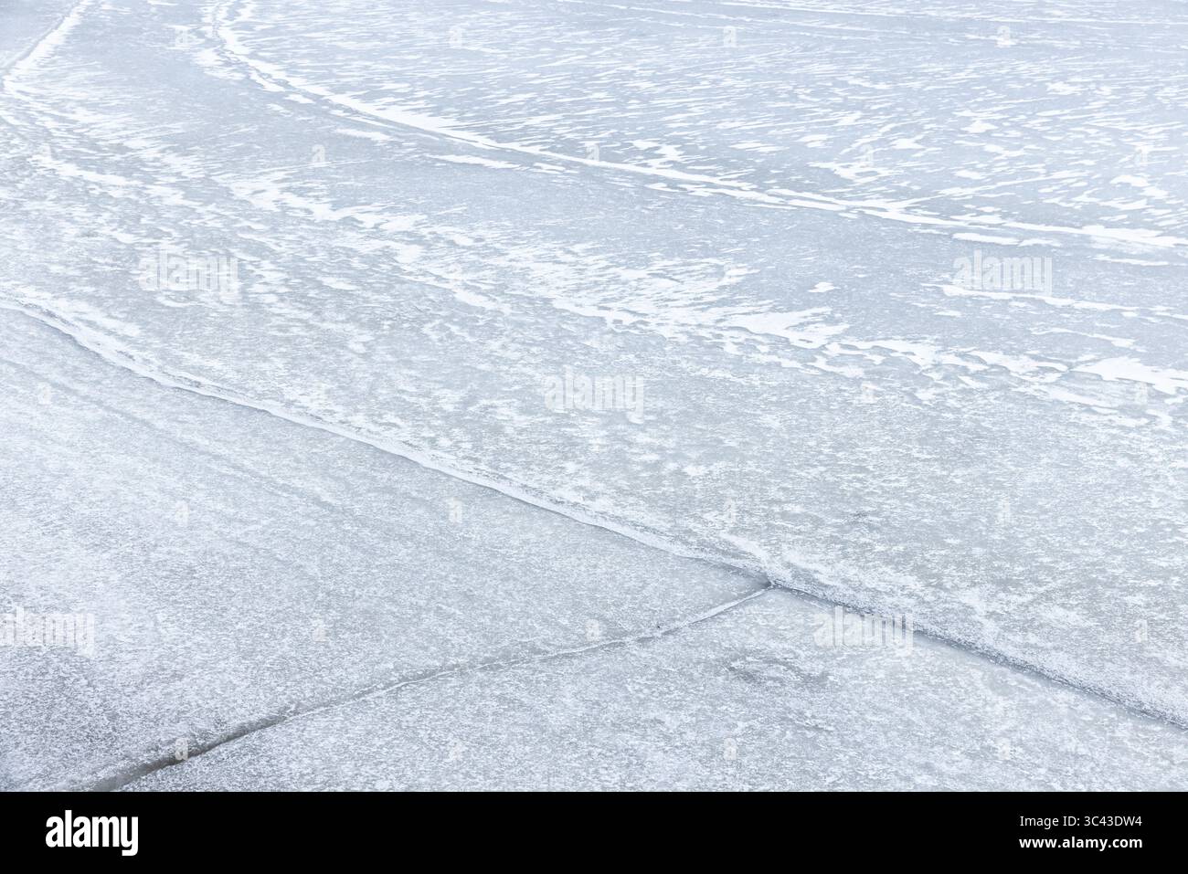 Superficie ghiacciata che mostra motivi e texture intricati, evocando freddo, tranquillità e bellezza naturale durante l'inverno. Ideale per design stagionali Foto Stock