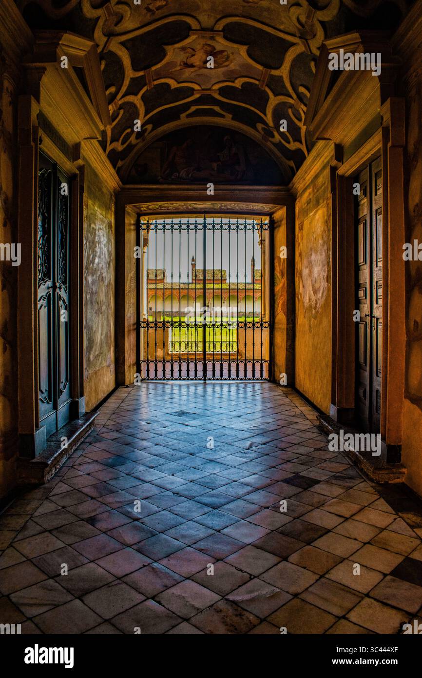 Italia: Il corridoio affrescato e la porta d'ingresso ai chiostri delle celle dei monaci della Certosa di Pavia, famoso complesso monastico lombardo (1396-1495) Foto Stock