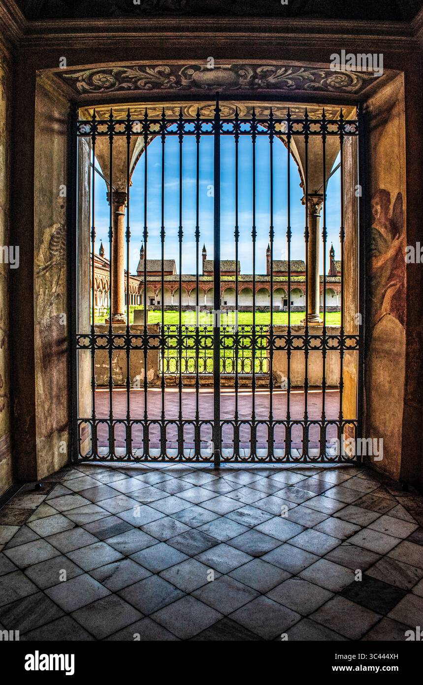 Italia: Il corridoio affrescato e la porta d'ingresso ai chiostri delle celle dei monaci della Certosa di Pavia, famoso complesso monastico lombardo (1396-1495) Foto Stock