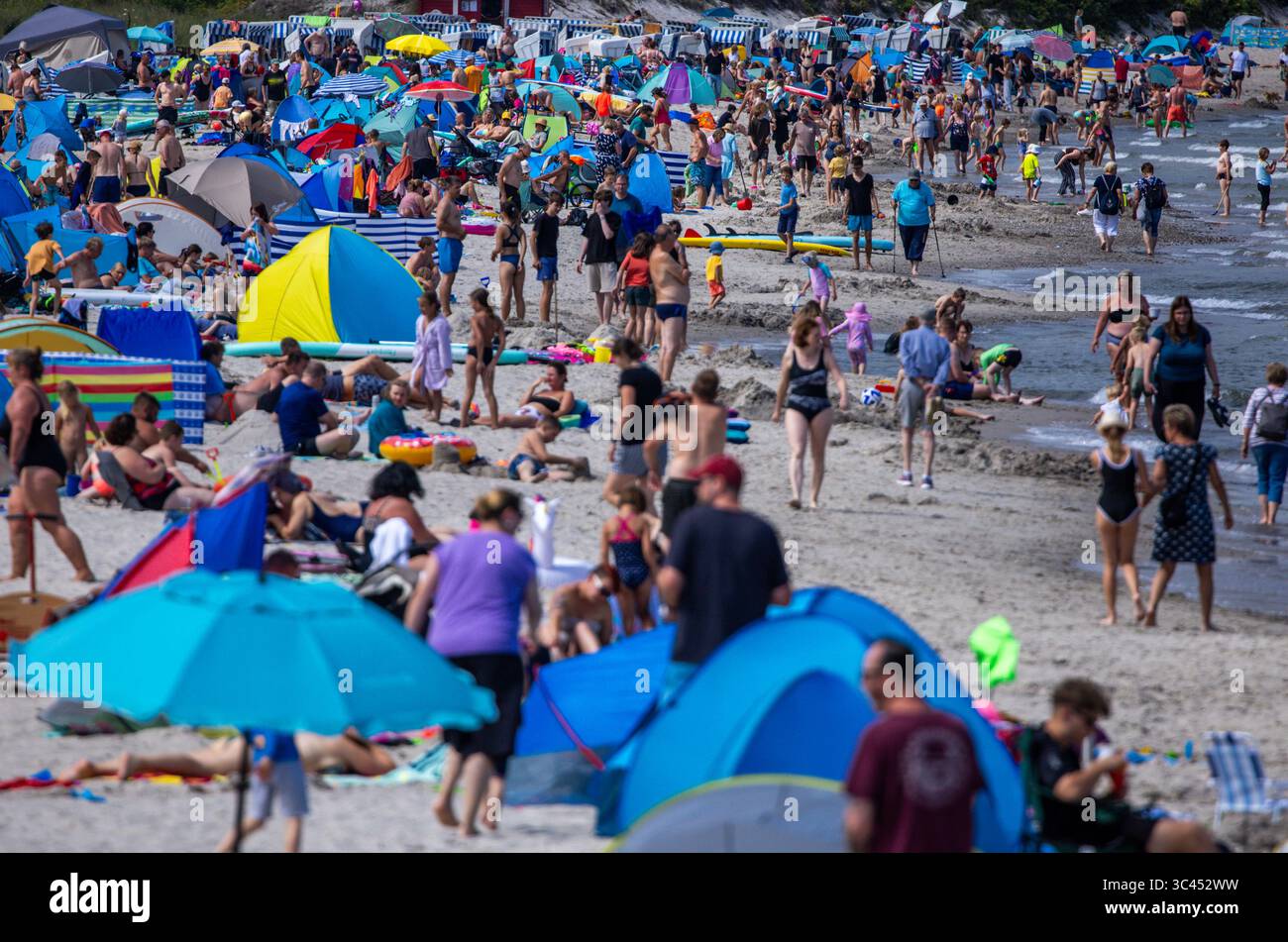 Boltenhagen, Germania. 28 luglio 2025. I turisti e i visitatori di un giorno approfittano del tempo parzialmente soleggiato per visitare la spiaggia del Mar Baltico. Dopo molti giorni di pioggia con temperature fredde, i meteorologi si aspettano più tempo estivo per i prossimi giorni, ma a metà settimana si prevedono venti forti e piogge rinnovate. Crediti: Jens Büttner/dpa/Alamy Live News Foto Stock