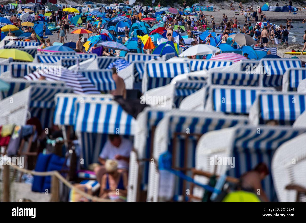 Boltenhagen, Germania. 28 luglio 2025. I turisti e i visitatori di un giorno approfittano del tempo parzialmente soleggiato per visitare la spiaggia del Mar Baltico. Dopo molti giorni di pioggia con temperature fredde, i meteorologi si aspettano più tempo estivo per i prossimi giorni, ma a metà settimana si prevedono venti forti e piogge rinnovate. Crediti: Jens Büttner/dpa/Alamy Live News Foto Stock