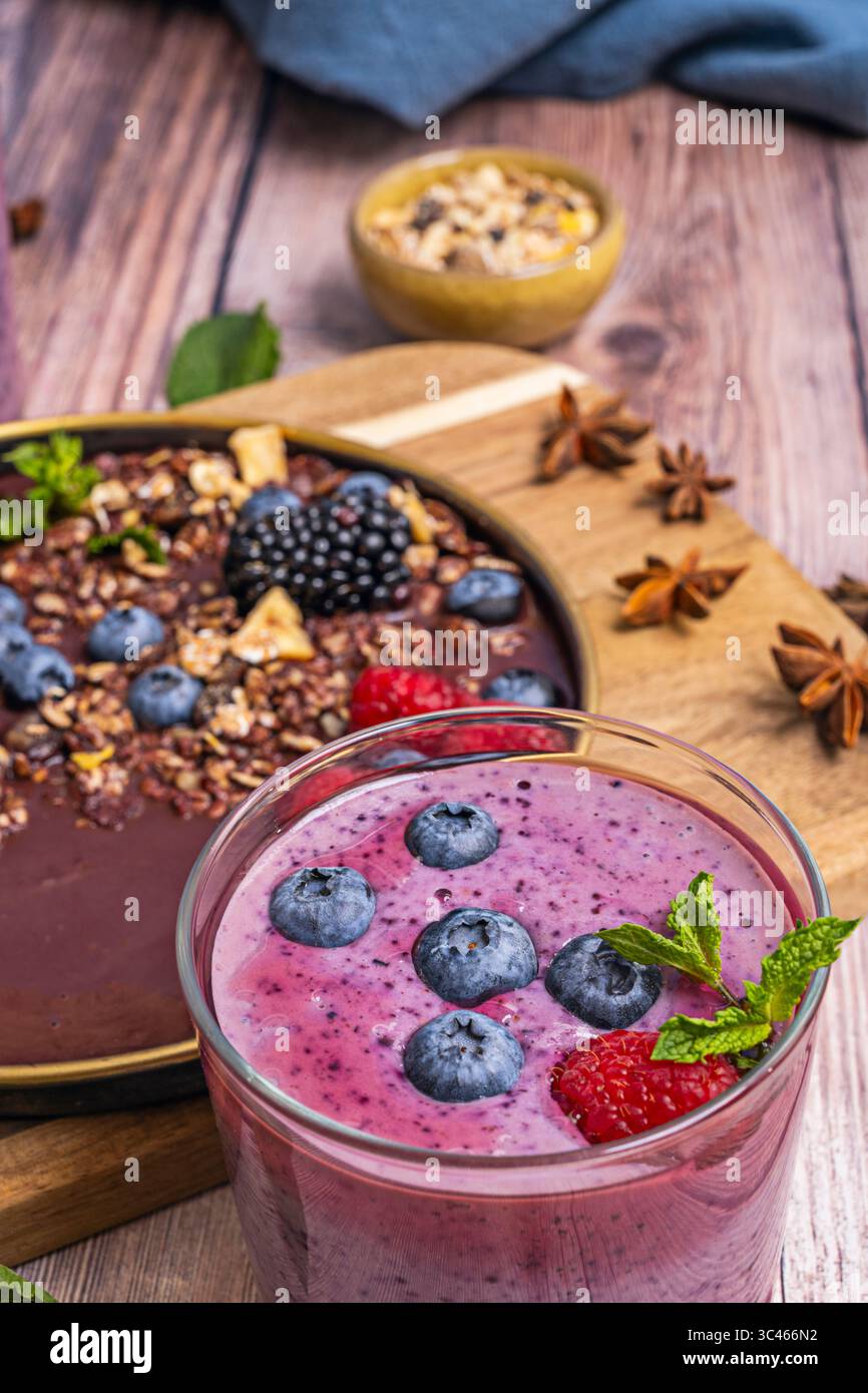 Frullato disintossicante di mirtilli, cetrioli e zenzero, in un bicchiere con etichetta "100% naturale" e sfondo biologico da cucina Foto Stock