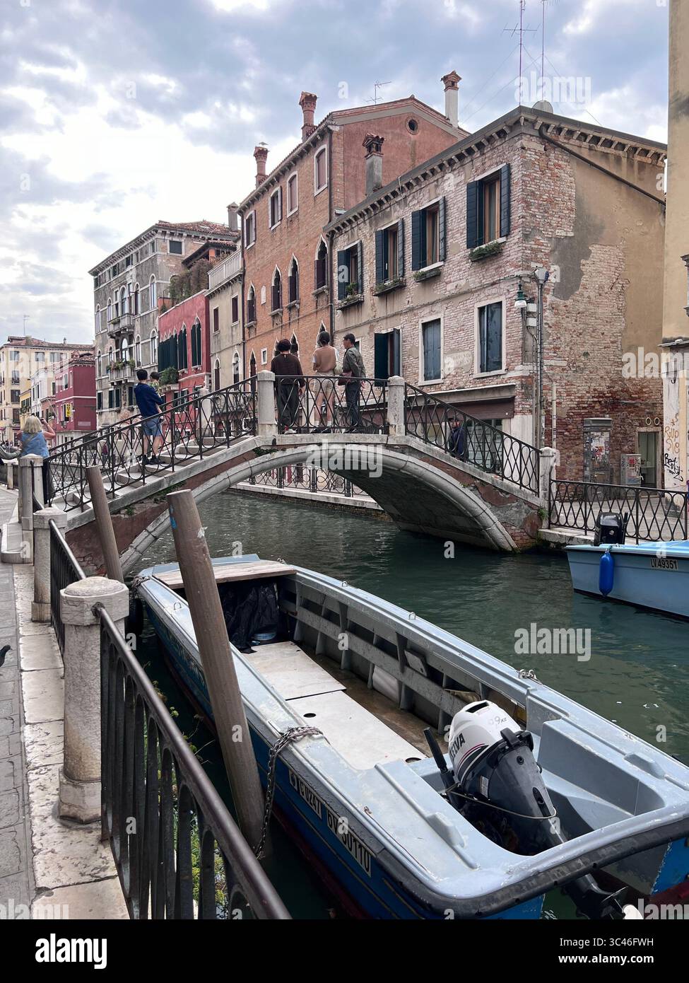 Una mattinata tranquilla a Venezia, con morbide increspature che danzano lungo antiche mura e balconi illuminati dal sole. Foto Stock