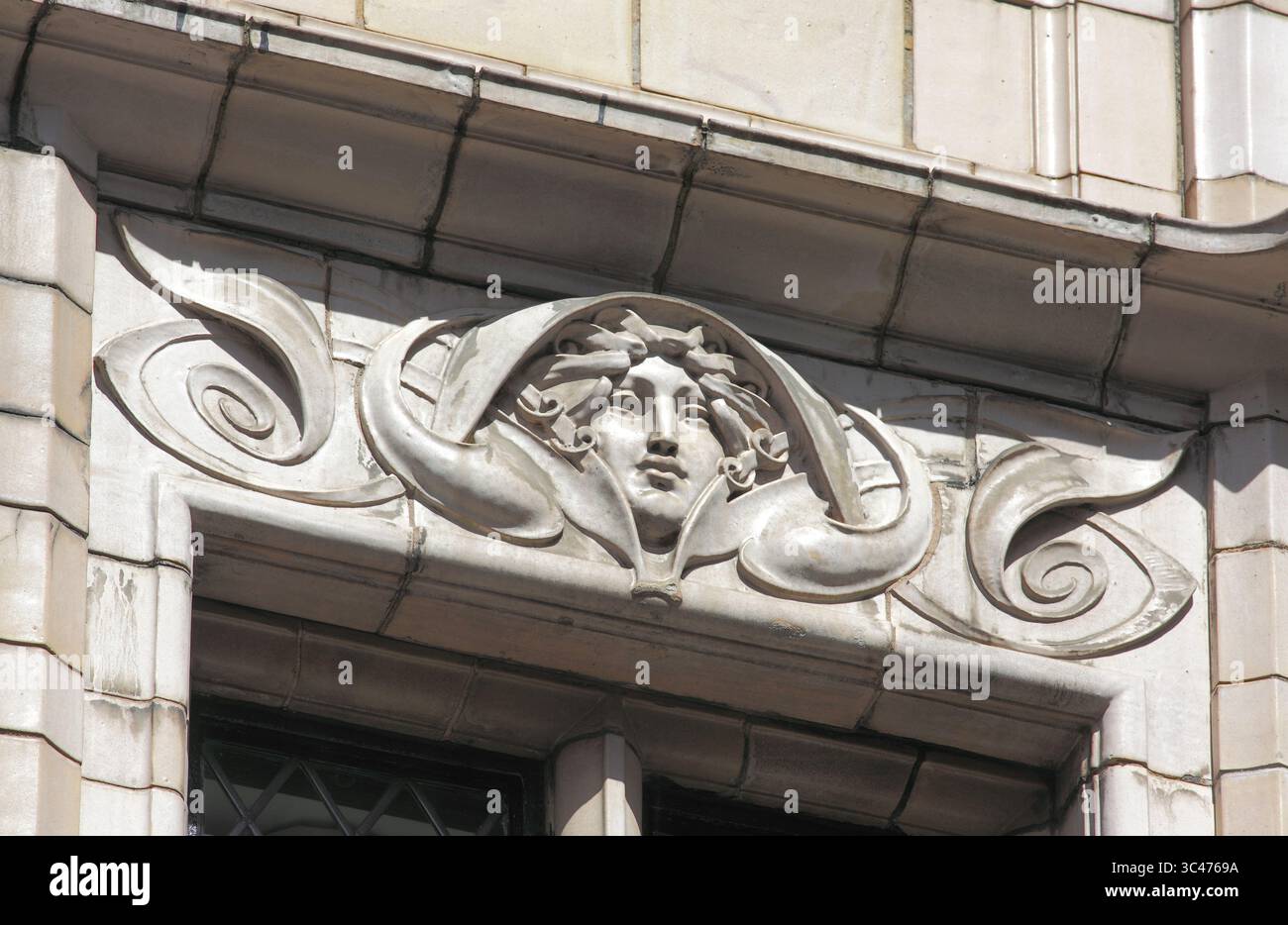 Testa femminile inserita in un vorticoso design Art Nouveau, sopra una finestra al secondo piano sulla facciata del pub Fox and Anchor, Chaterhouse St, Londra. Foto Stock