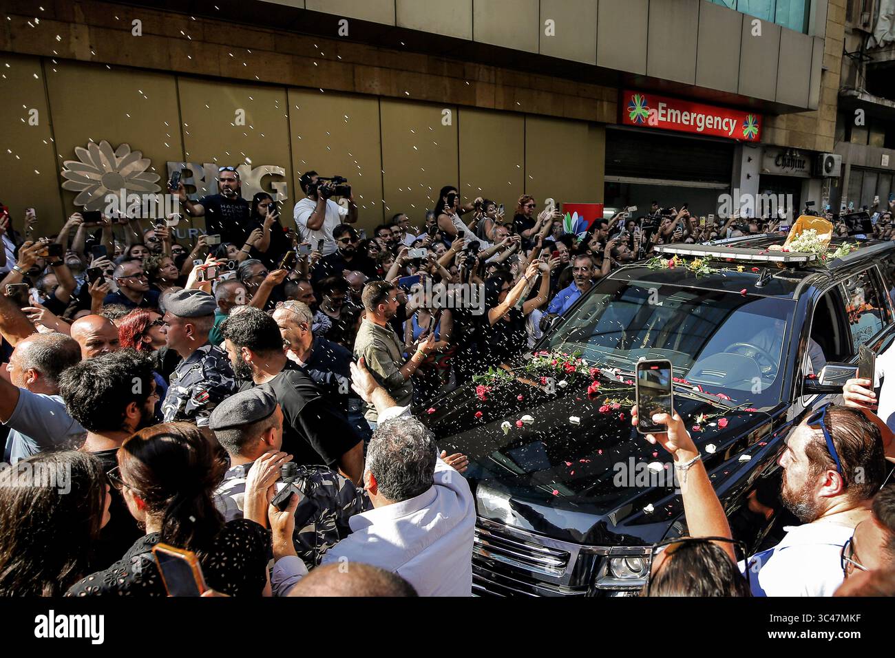 28 luglio 2025, Libano, Bikfaya: I libanesi lanciano riso e fiori mentre circondano l'auto portando la bara del compositore libanese, drammaturgo e attivista politico Ziad Rahbani, in una chiesa locale nel villaggio di Bikfaya. Rahbani, morto sabato scorso, era il figlio maggiore del leggendario cantante libanese Fayrouz e del defunto compositore assi Rahbani. ·divenne famoso con le sue opere artistiche e la musica che sfidava i generi che sfidavano le strutture politiche, settarie e sociali del Libano, diventando una delle voci culturali più influenti del mondo arabo. Foto: Marwan Naamani/dpa Foto Stock