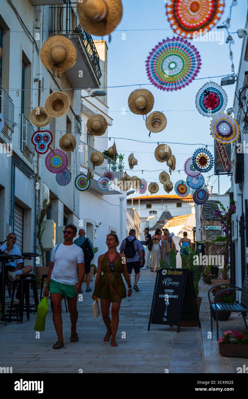 Strada decorata con cappelli appesi ad Alberobello, Puglia, Italia Foto Stock