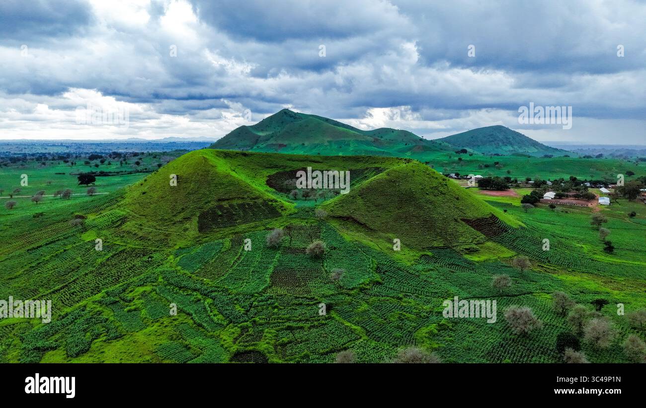 Vista aerea del vivace paesaggio verde, con colline ondulate sotto un cielo nuvoloso, Kereng, Plateau, Nigeria. Foto Stock