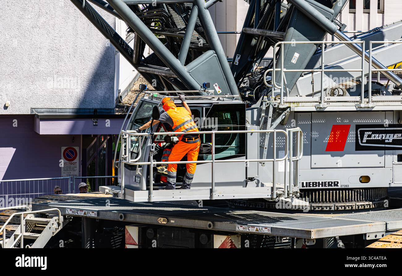 Kloten, Svizzera, 12 luglio 2025: L'operatore della gru cingolata Lieberherr LR 1750/2 da 750 tonnellate riceve le istruzioni finali. (Foto di Andre Foto Stock