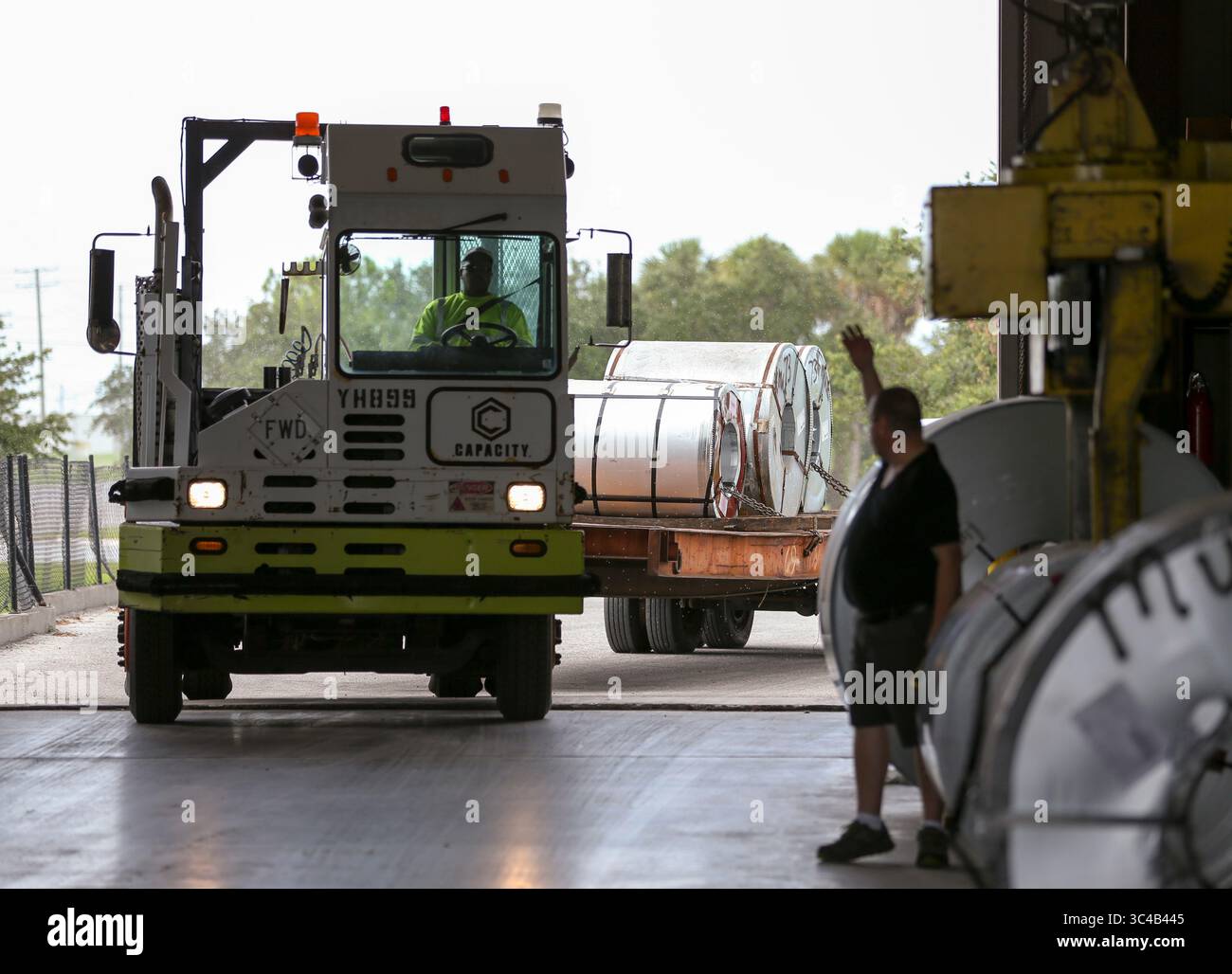 19 luglio 2018 - Tampa, Florida, Stati Uniti - CHRIS URSO | Times.John Lloyd, un operatore di ricezione e gru presso Titan Metal Service, Inc., a destra, ondeggia in un camion che trasporta acciaio laminato presso lo stabilimento di Port Tampa dell'azienda giovedì 19 luglio 2018. Le tariffe dell'amministrazione Trump stanno interessando varie aziende nell'area di Tampa Bay e in Florida. Titan Metal Service, Inc. Acquista acciaio da paesi nazionali ed esteri e lo riduce a dimensioni utilizzabili per i produttori. (Immagine di credito: © Chris Urso/Tampa Bay Times tramite ZUMA Wire) Foto Stock