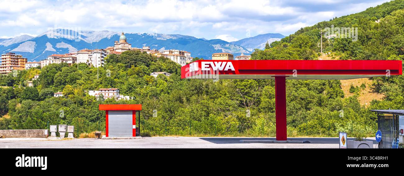 Stazione di benzina EWA lungo la strada Sora-Cassino in Italia Lazio, con il centro storico di Atina città sullo sfondo, ampio colpo Foto Stock